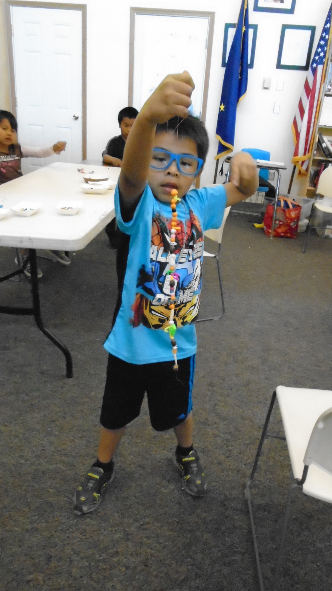 A student shows off his result of the beading instruction.