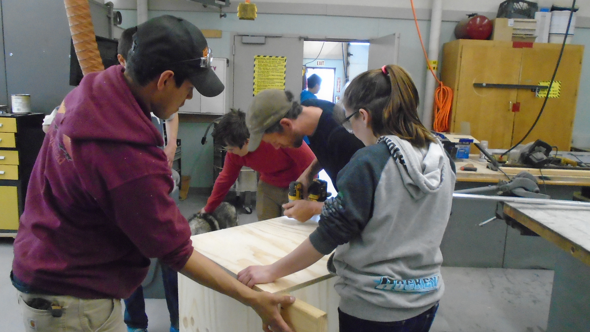 Students buidl dog house in shop with Jessie Holmes and Joe Bifelt.