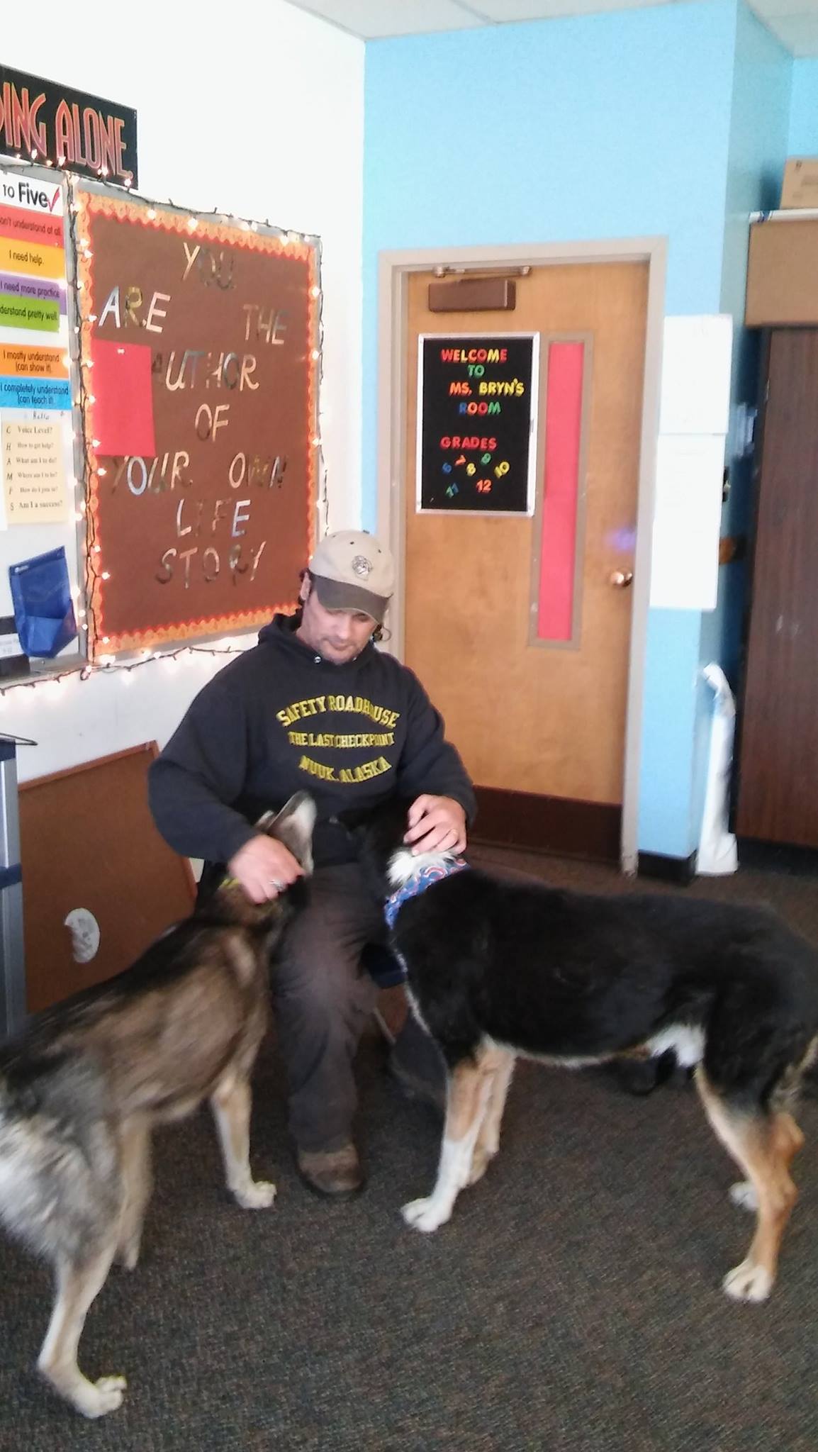 Dog Musher Teacher Hugh Bifelt with dogs and students in classroom.