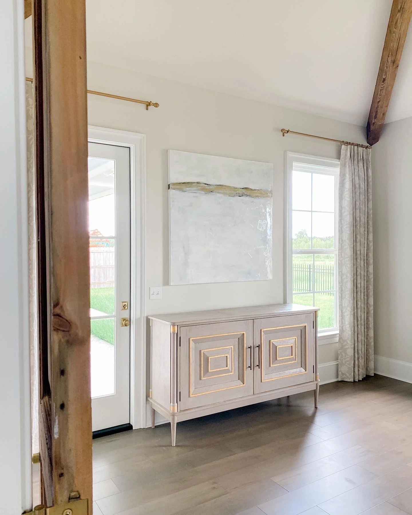 Large abstract neutral wall art hangs in a bedroom over a hutch.neautral wall art