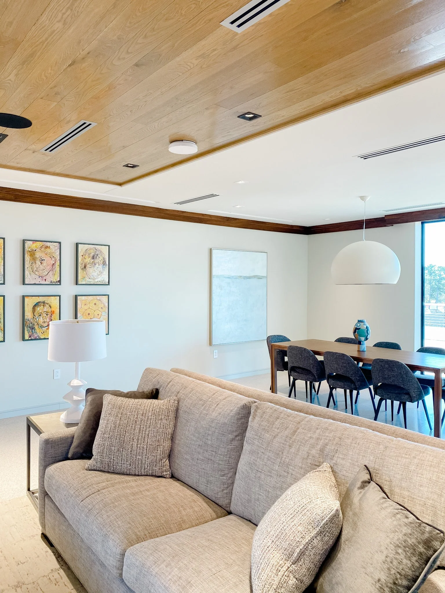 Large abstract neutral artwork with soft blues and grey hangs in a dining room.