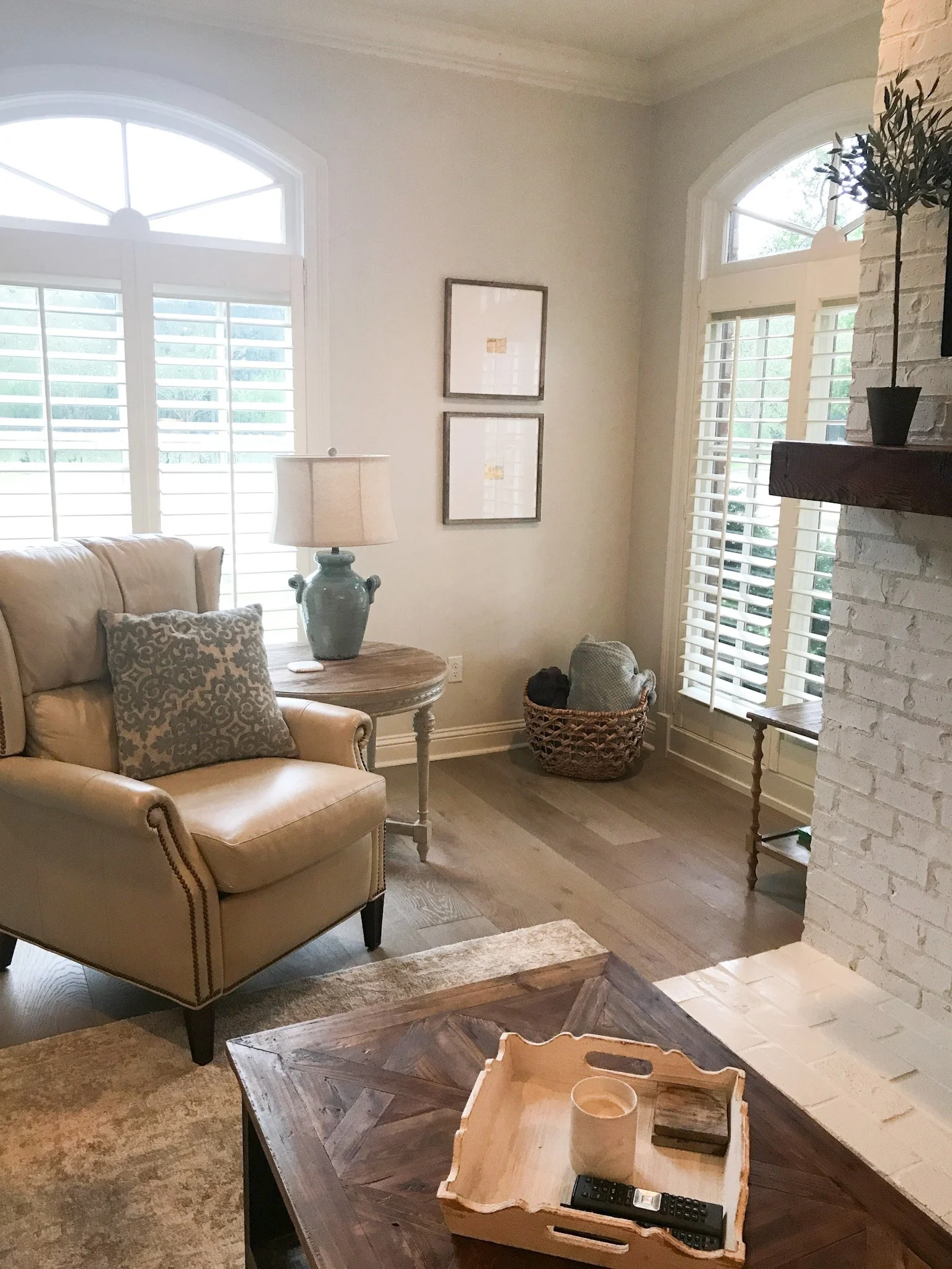Original neutral small framed artwork hangs in a living room.