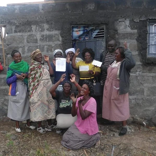 Members of the Muungano Wa Wanavijiji Nakuru West Network, receive a cheque from AMT's Board member Anastacia Wairimu for the Shikamoo D housing project