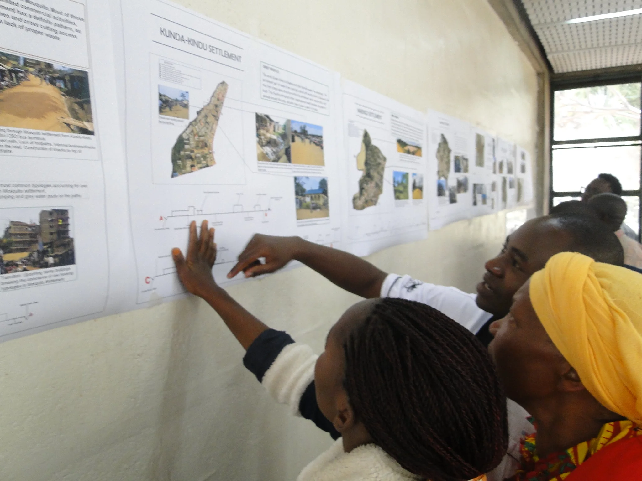 Members of five settlements in Kitui Town interact with data they collected during the Kitui Studio data collection process at the University of Nairobi.