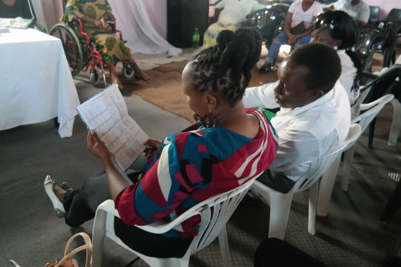 Mary Wambui (Kenya SDI Alliance) and John Mulia (Kenya Official) look at FEDUP savings book