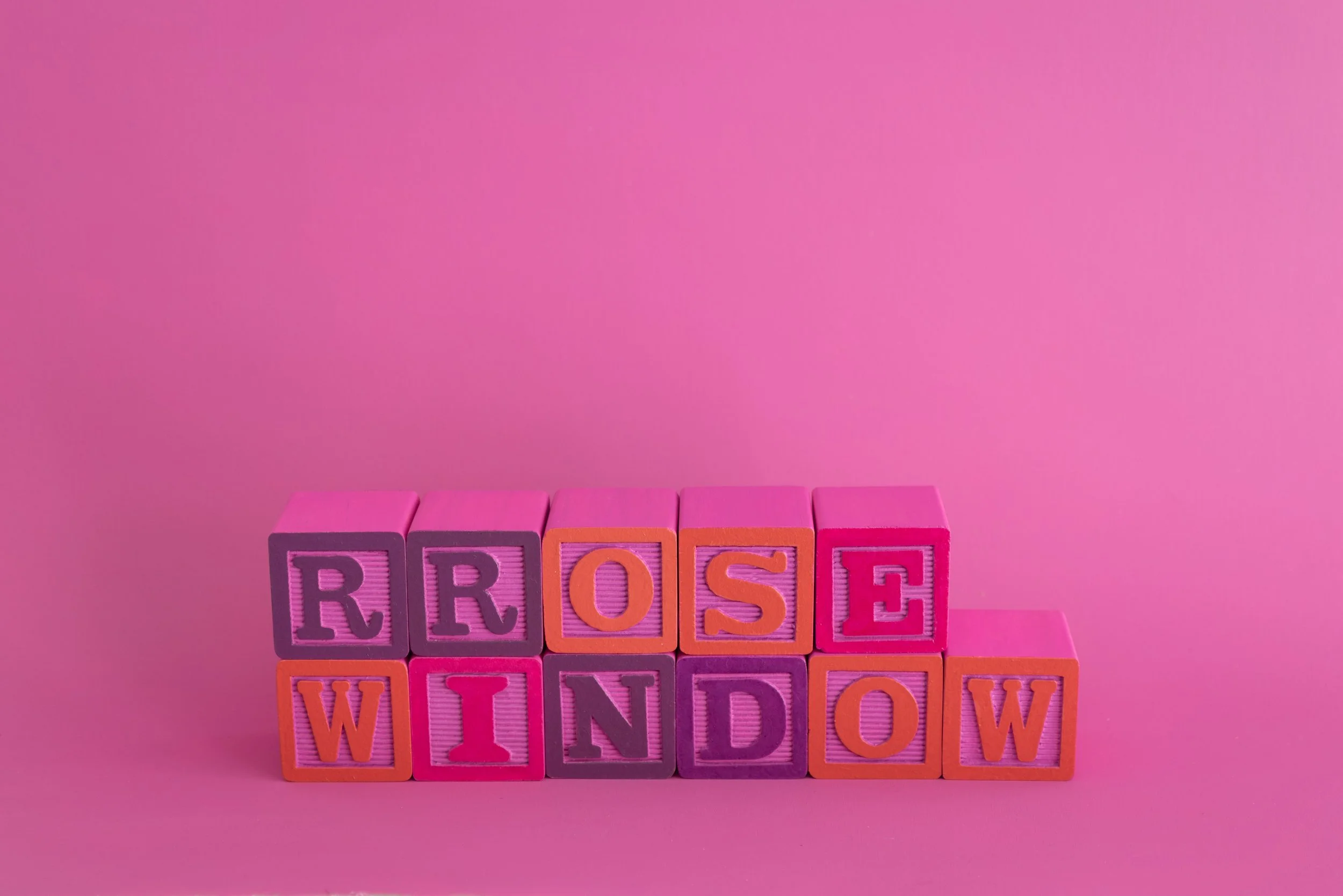 painted alphabet blocks spelling the words “Rrose Window”