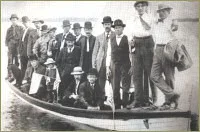Many special occasions such as Midsummer's Day and Syttende Mai (May 17th, Norwegian Independence Day), were celebrated to preserve ethnic traditions. On special outings, miners often dressed in their best suits as shown in this photo they posed in a sailboat on Rabbit Lake.