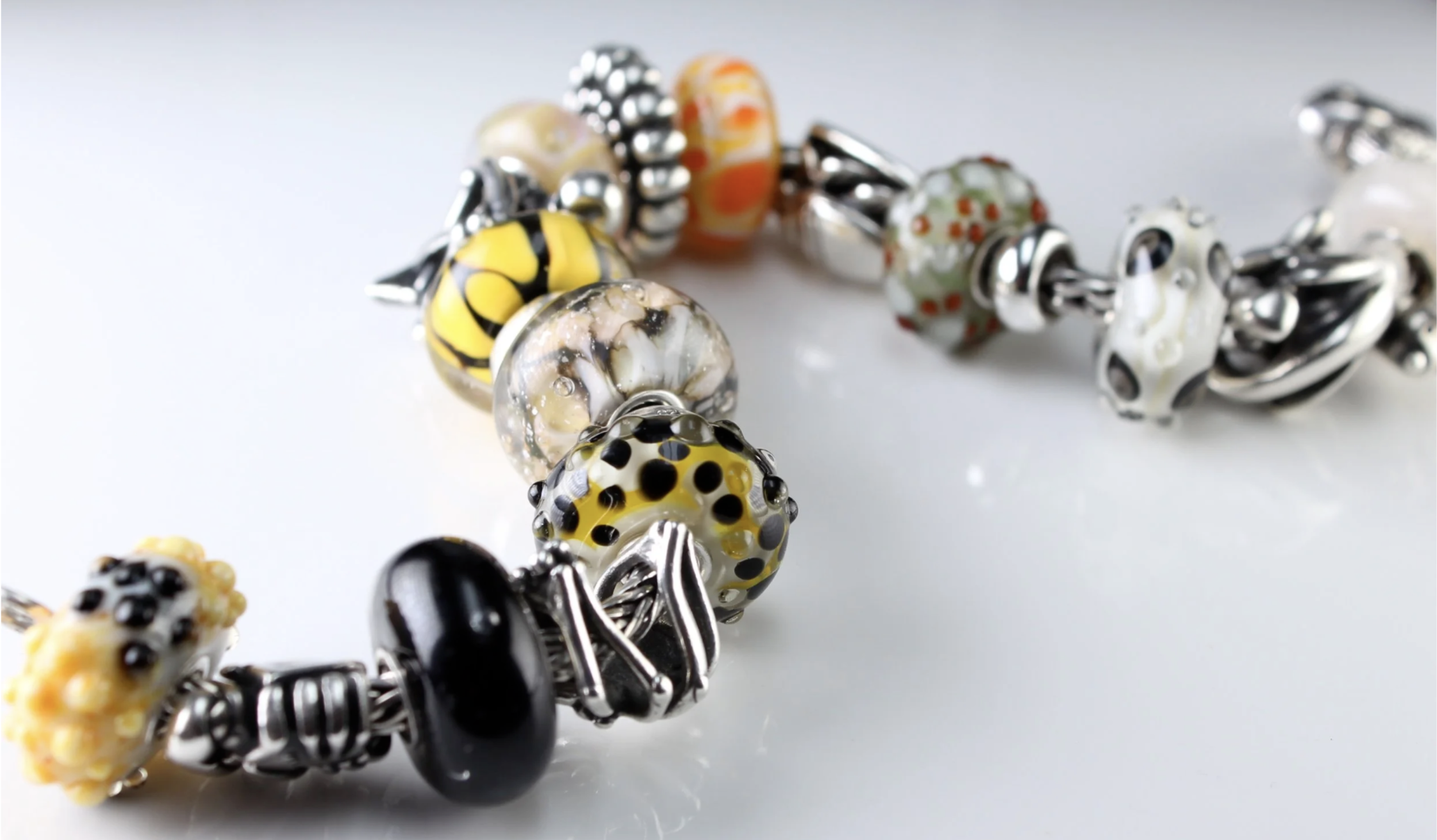 Close-up image of a colorful beaded bracelet on a white surface.