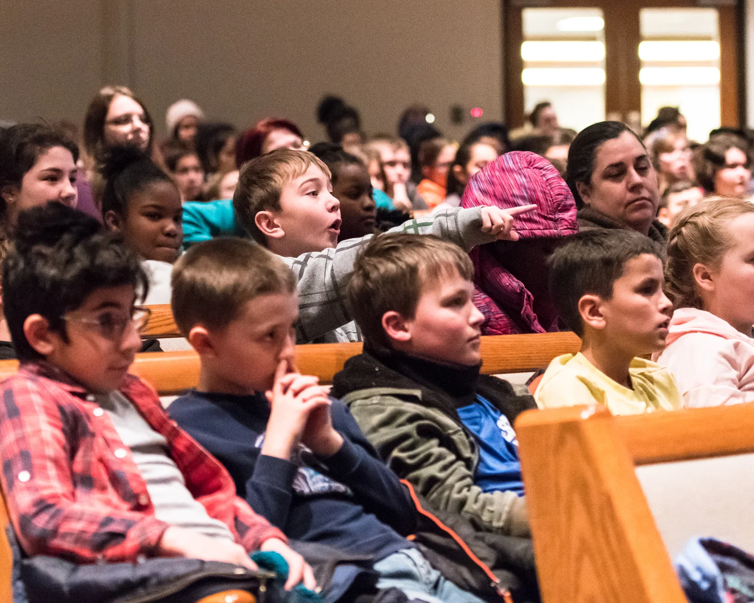Taylor Fischer from Olympia Brown Elementary points as he answers the conductor's question about the previously played selection by composer Joseph Haydn during the Racine Symphony Orchestra's Concert for Fifth Graders held Tuesday at Grace Church in Caledonia