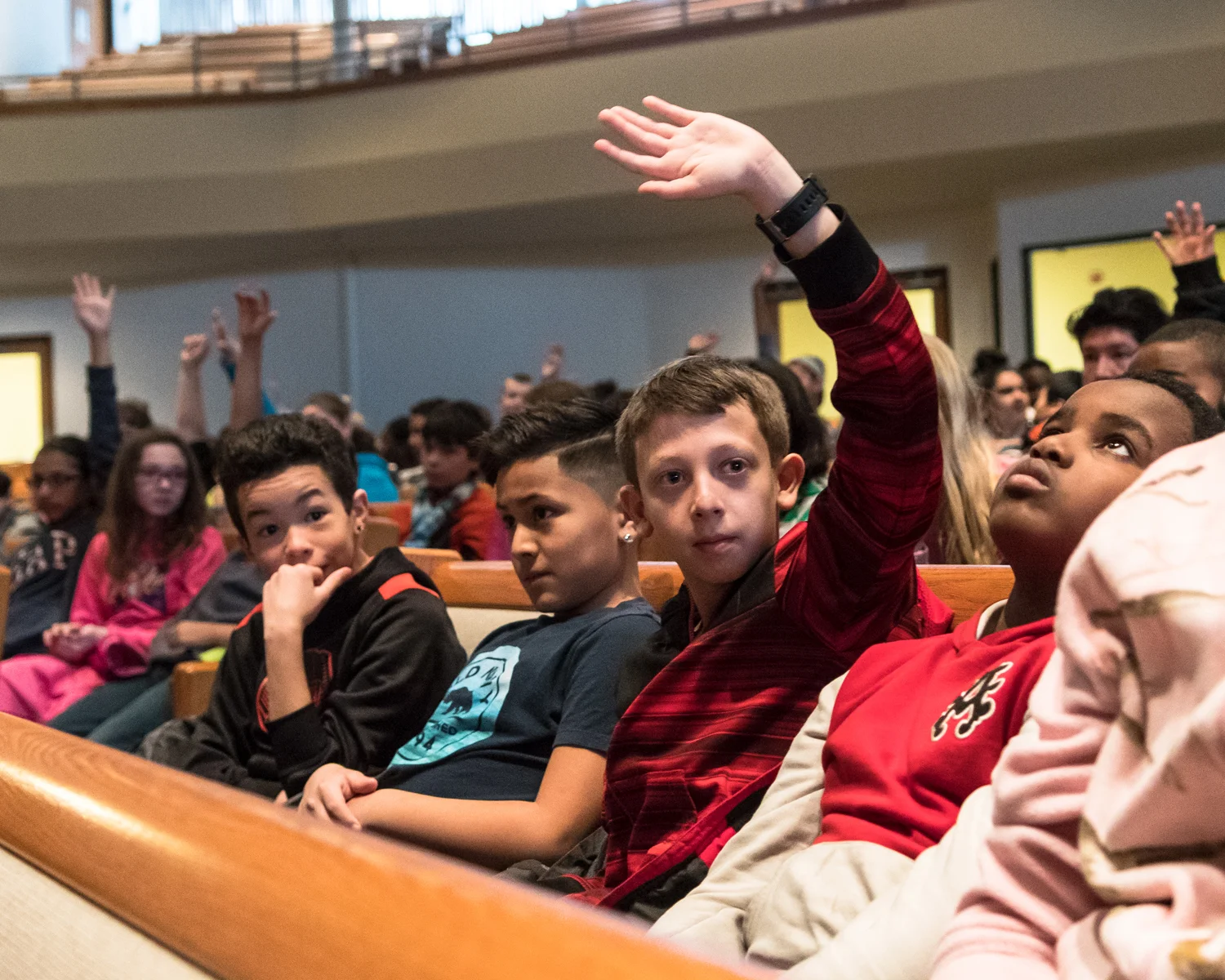 Fifth-grader John Rodgers, an aspiring trombone player from Wadewitz Elementary School, raises his hand when brass instrument players are called on by the Racine Symphony Orchestra conductor Pasquale Laurino during the RSO's Concert for Fifth Graders on Tuesday, March 14, at Grace Church in Caledonia