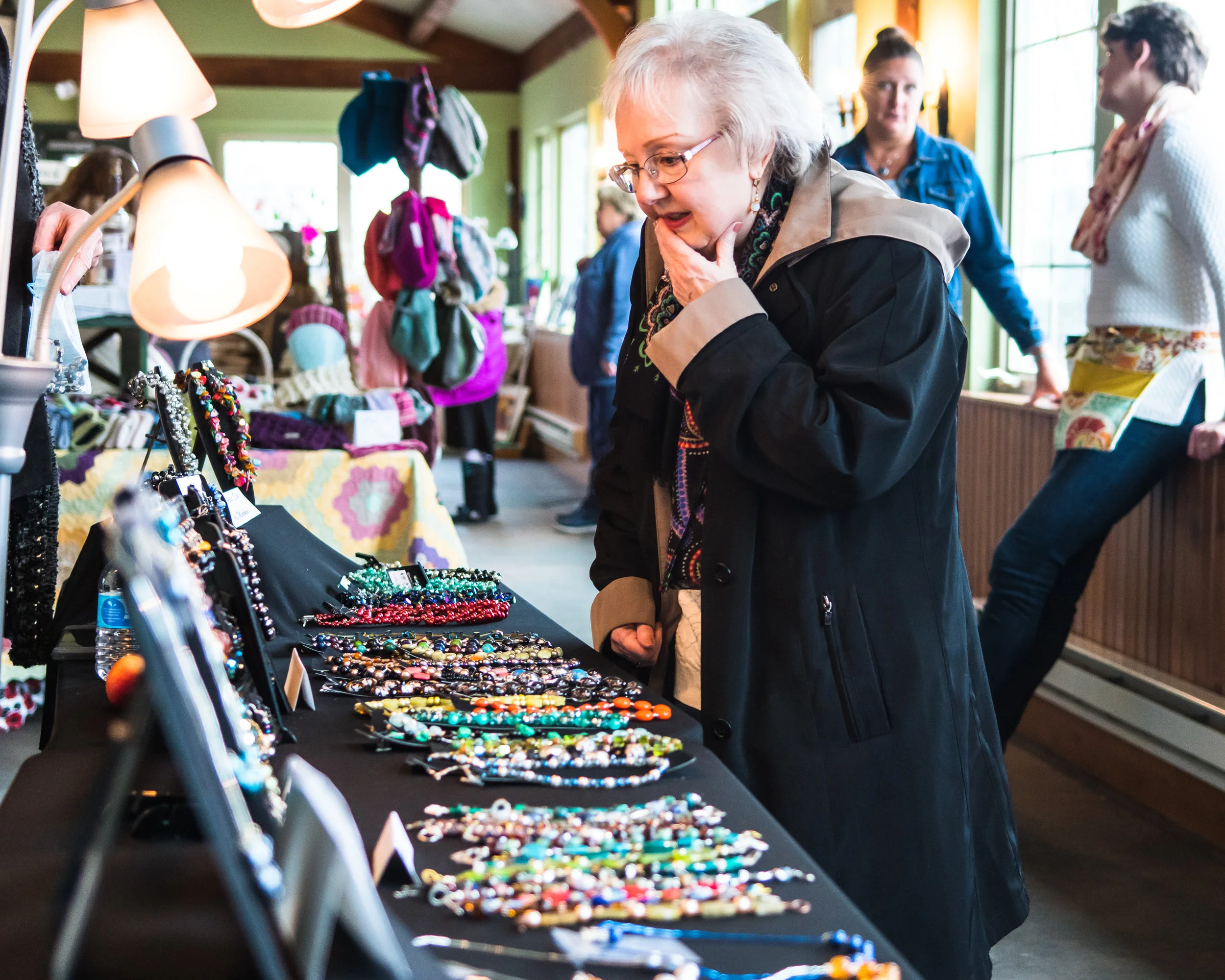 Decisions, Decisions--Karen Buswell looks over the jewelry selection of Linda Glass, of Designs by Glass, during the Spring Arts & Craft Fair at Borzynski's Farm and Floral Market, 11600 Washington Ave., Mount Pleasant, on Sunday. 