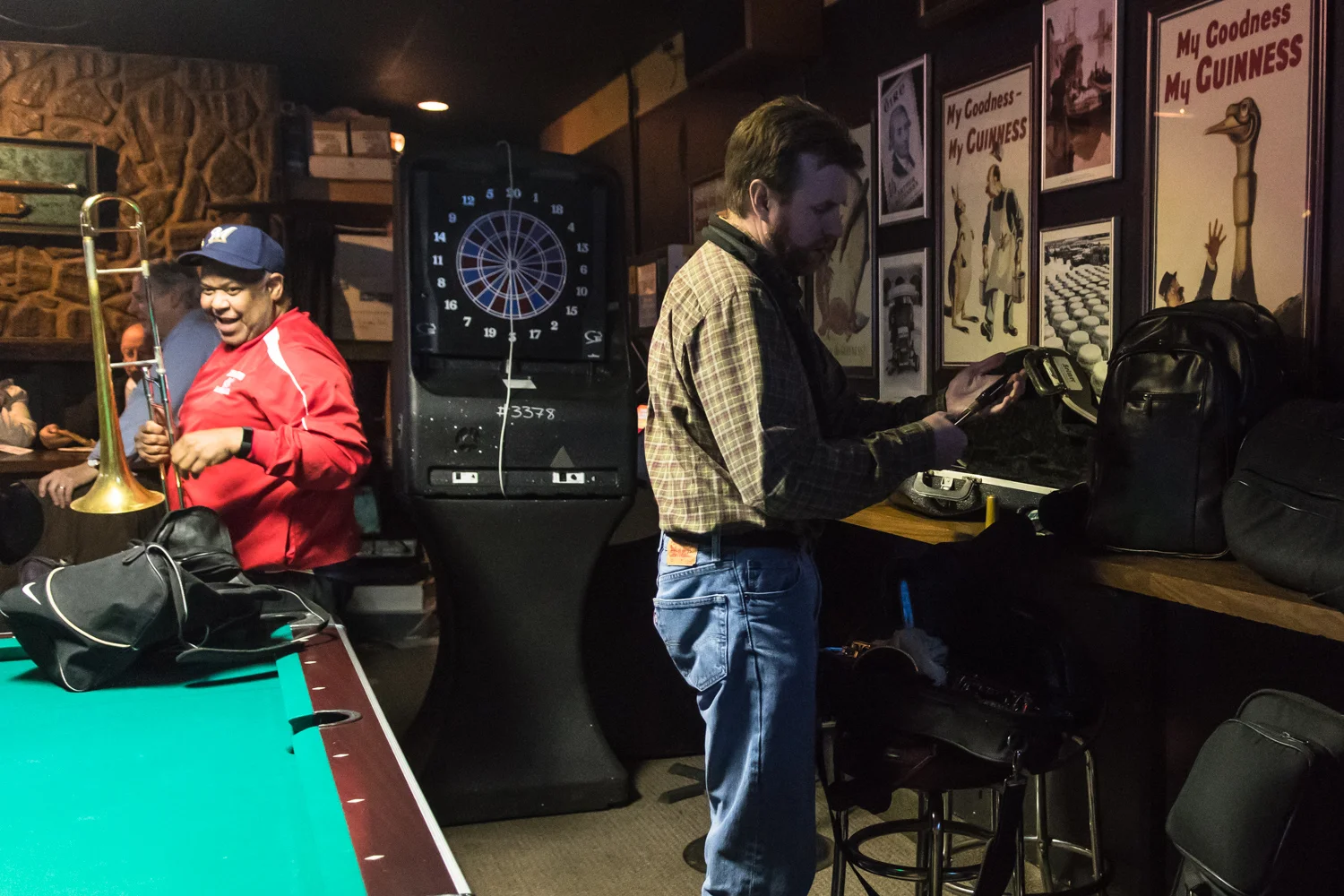 Dave Ferguson, Trombone, and Garrett Kornman, Alto Saxophone player, unpack their instruments around the pool table of McAuliffe’s Pub for The Parkside Reunion Big Band’s bi-weekly performance on April 4.