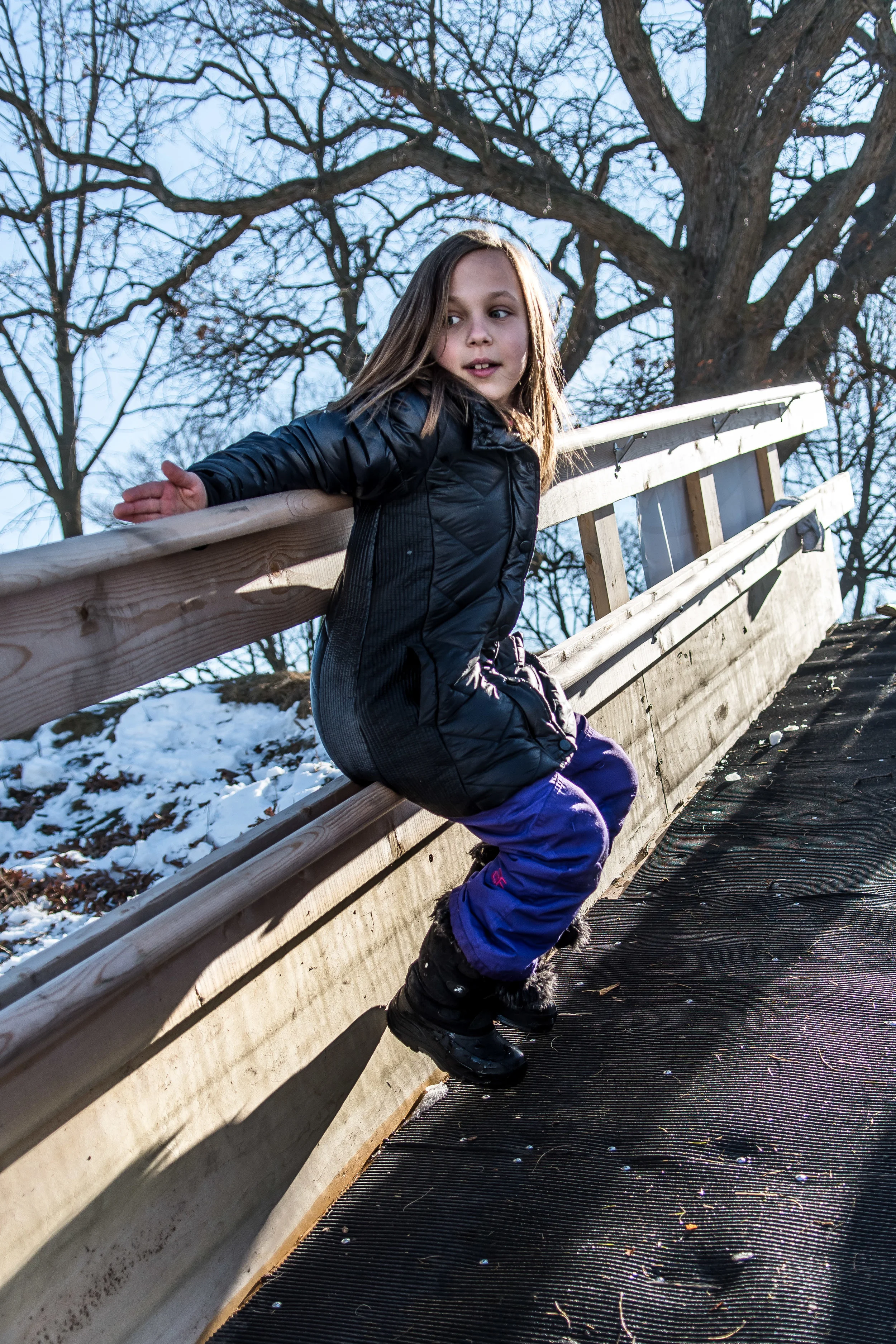 Paige Bemau, 8, slides down the railing of the ramp leading onto the frozen water of Echo Lake Saturday afternoon during Burlington’s Hot Chocolatefest.