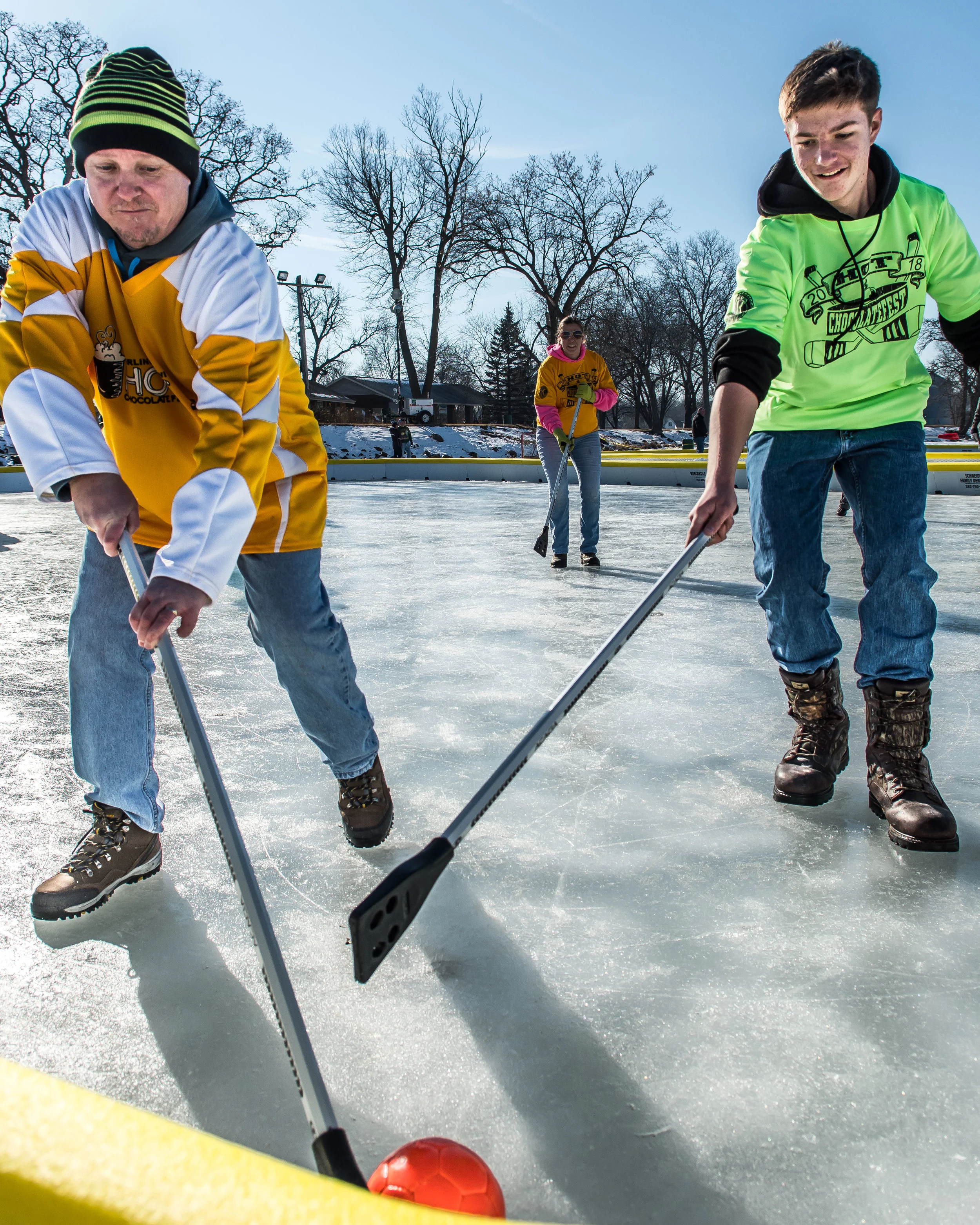 Jeff Van Lysal runs for the ball closely followed by Matthew Oliver, 14, during an adults versus kids game of Broom Ball on Echo Lake during Burlington’s Hot Chocolatefest Saturday afternoon.