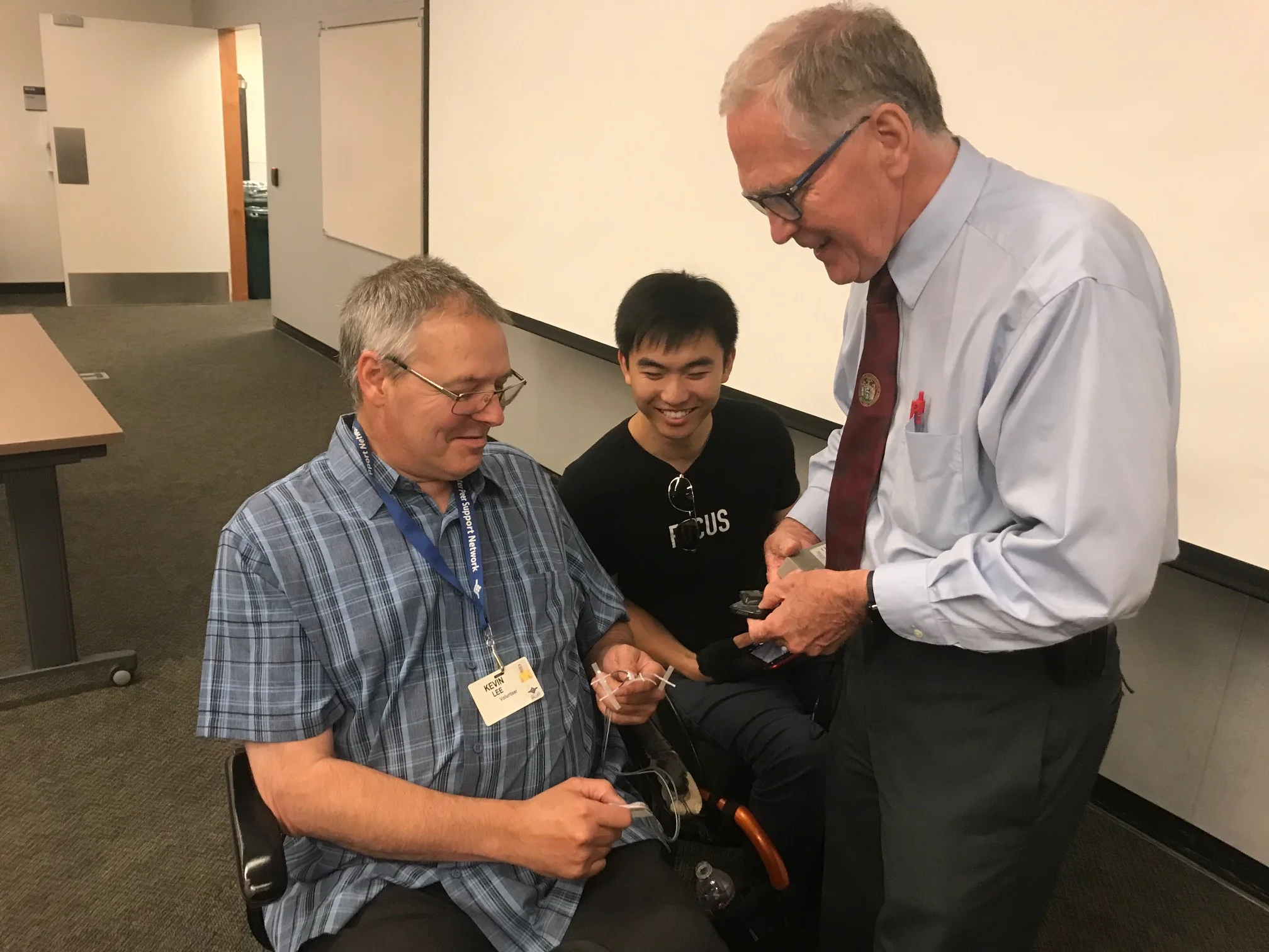 Dr. Creasey showing Kevin Lee (in front) and Ran Tao the electrodes used in the procedure.