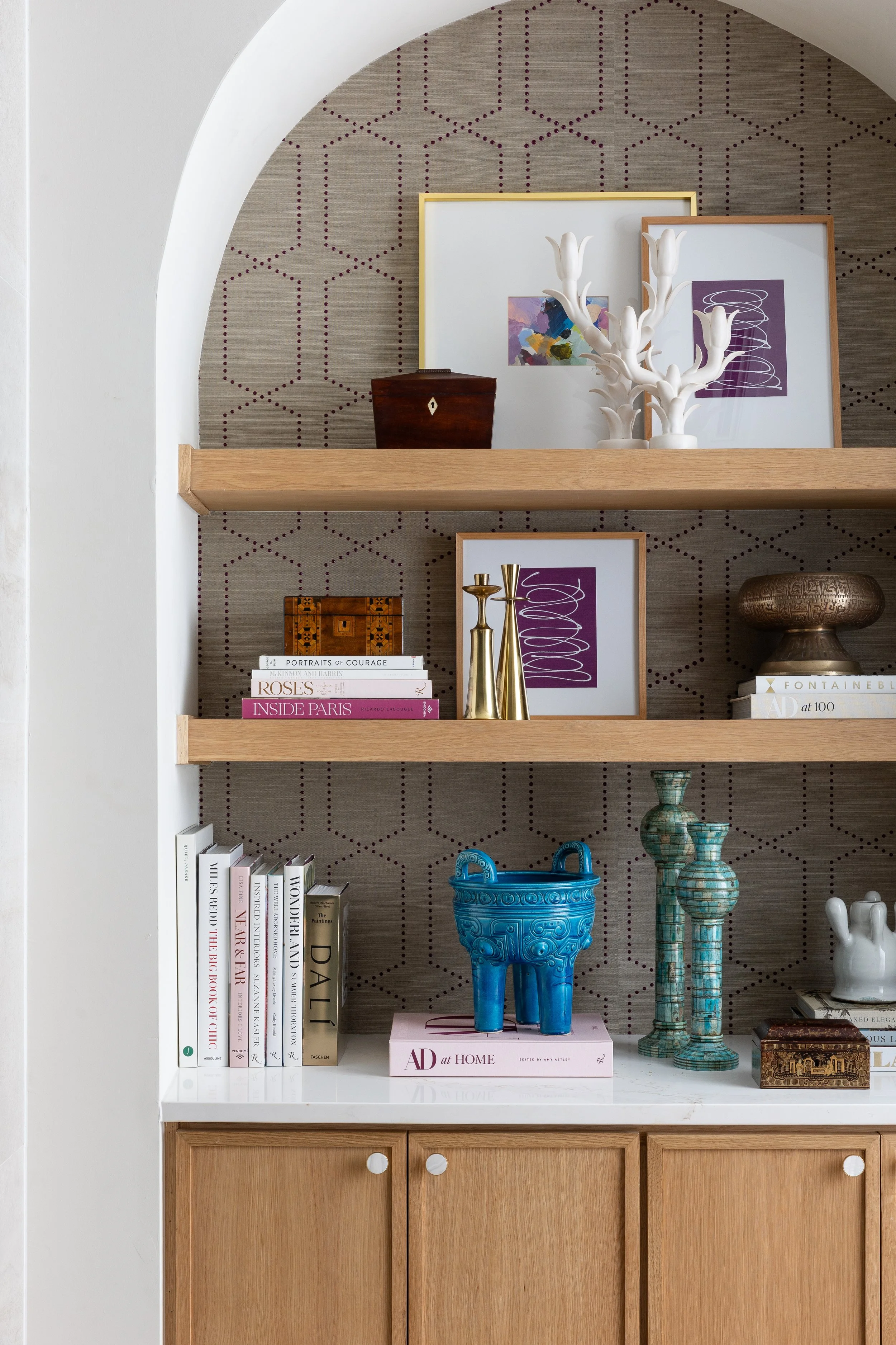 Styled bookshelves in living room with jewel tones