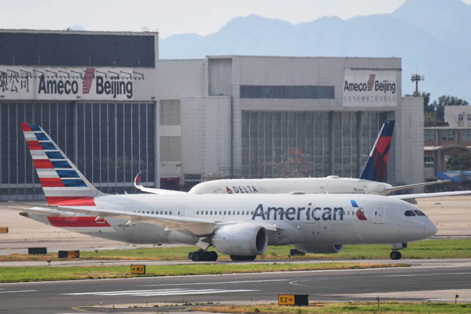 An American Airlines Boeing 787 and Delta Air Lines Airbus A350 aircraft wait to take off at Beijing airport. Subsidies for airplane manufacturers are becoming a sticking point in American-European trade policy. Credit Greg Baker/Agence France-Presse — Getty Images