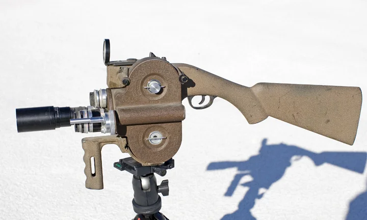 Filmo 16mm Movie Camera Standard Filmo 3-lens turret camera, but mounted in a rifle stock with a dot reticle gunsight.