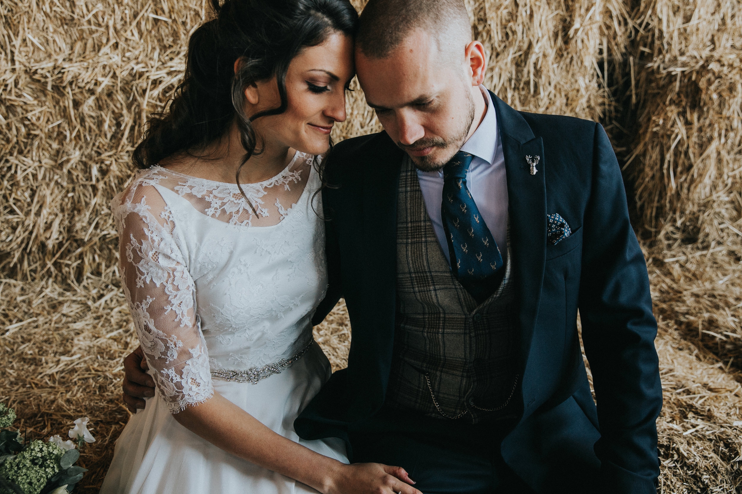 Couple cuddling on hay bale