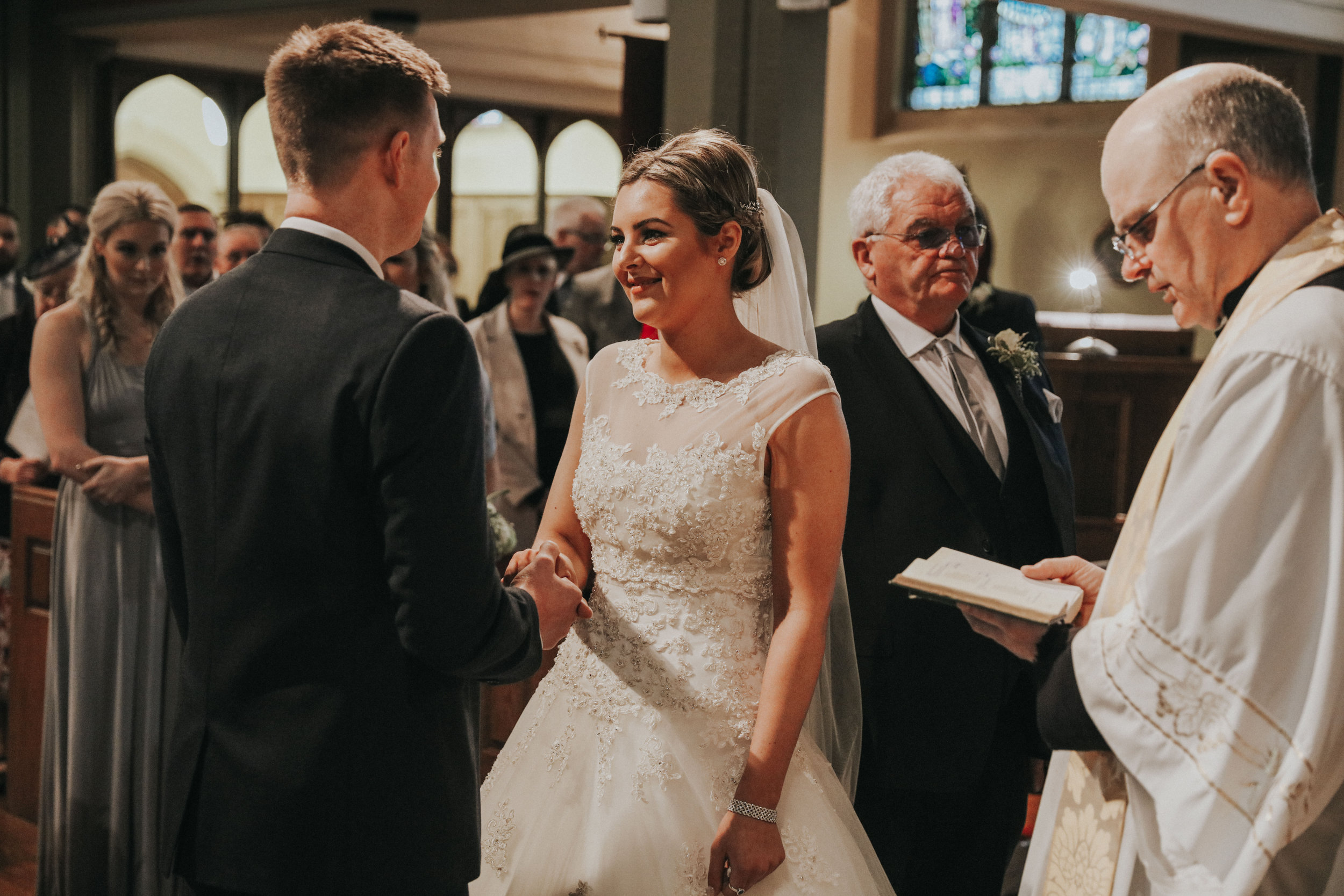 groom holding brides hand at altar