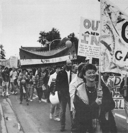Black and white photo of the first Halifax pride march (1988). A group of people holding signs and banners