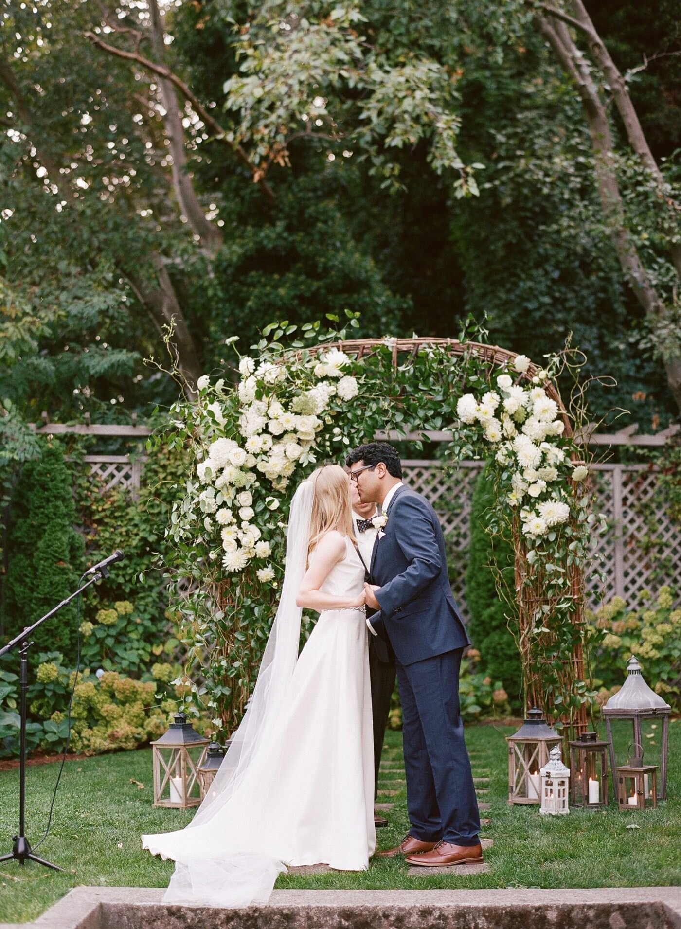 First kiss at an Admiral's House wedding with green and white floral design