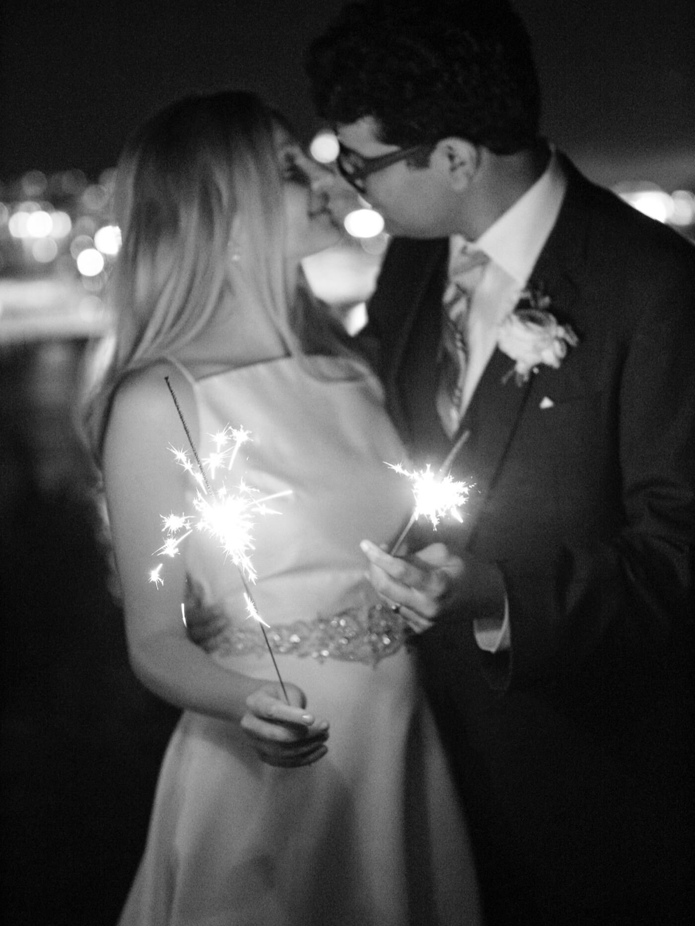 Bride and groom kiss with sparklers after their wedding at The Admiral's House