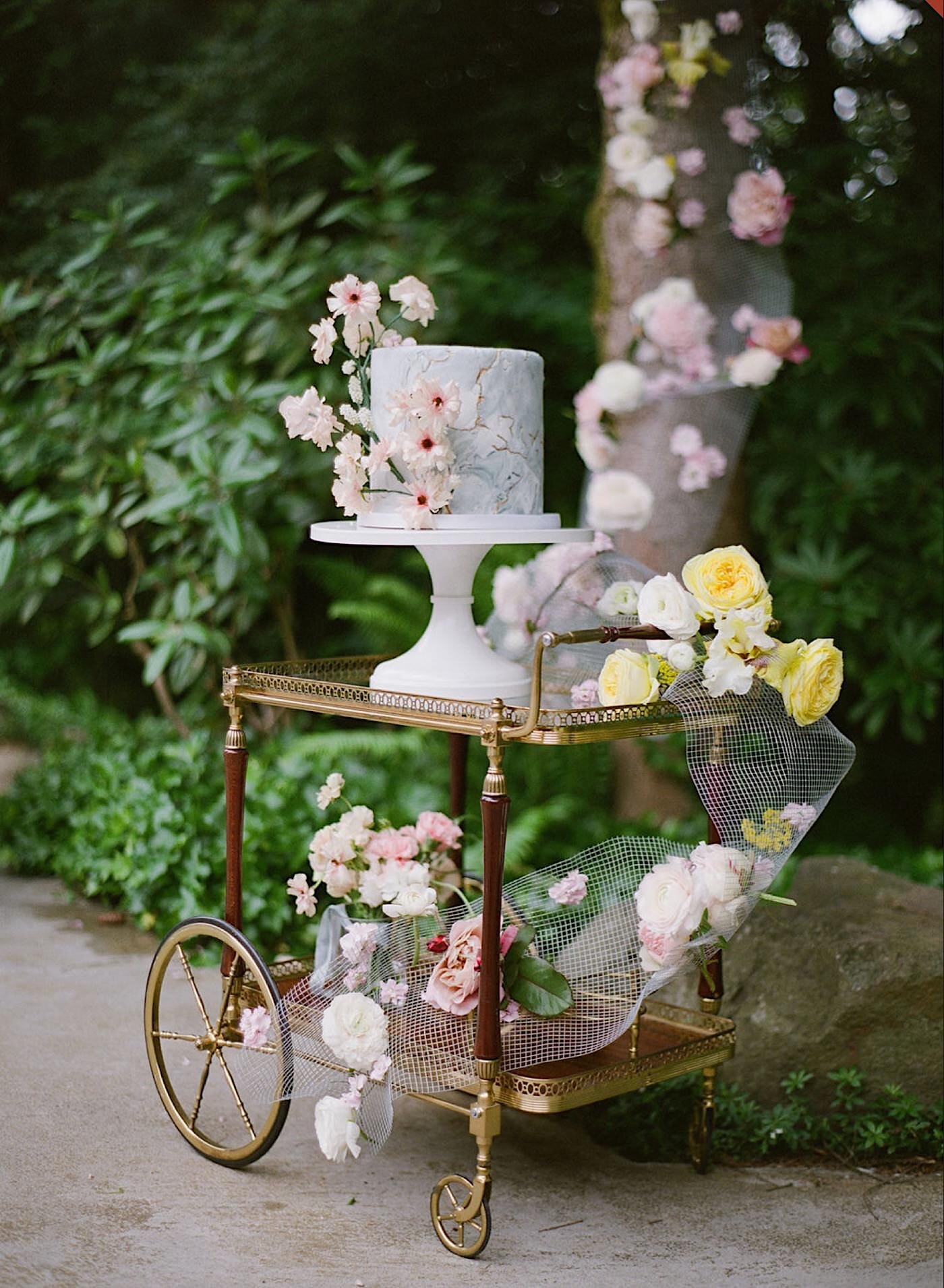 Lush cake display with cascading floral installation