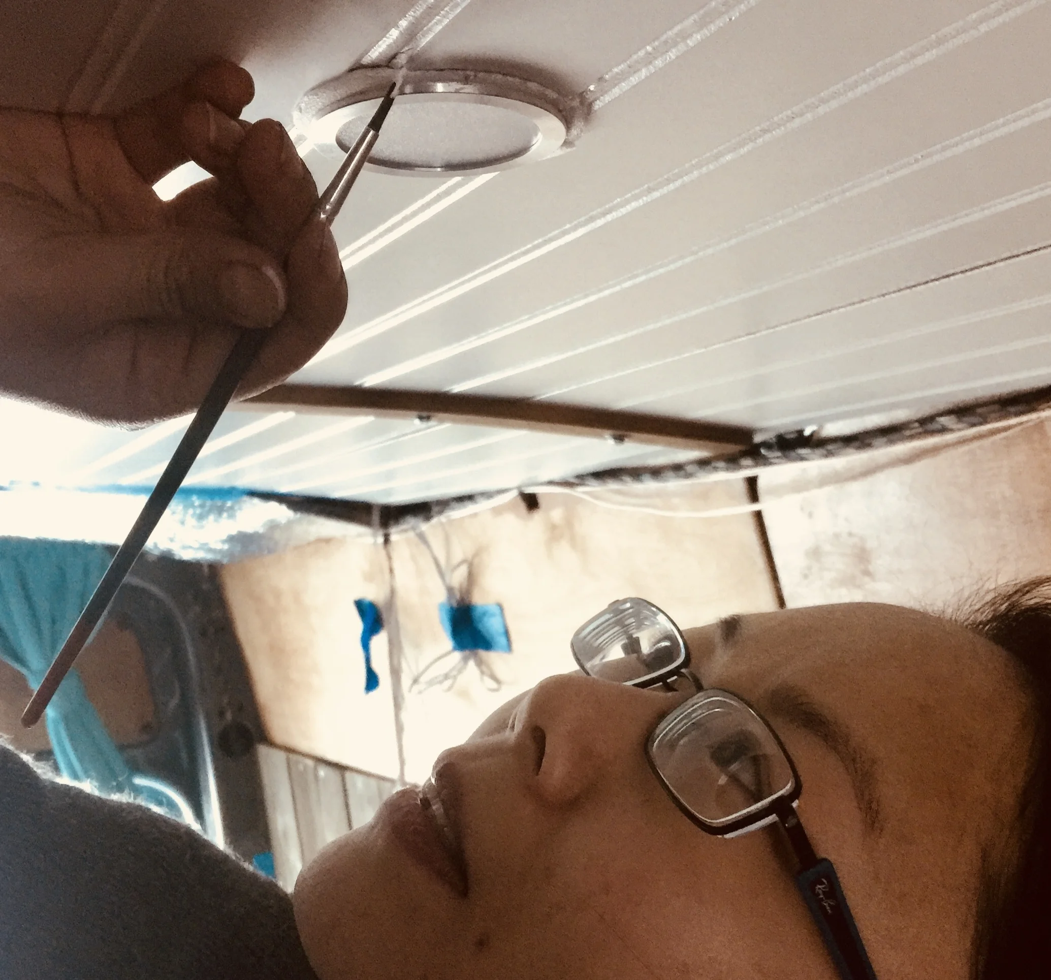 Shelly painting the ceiling with white acrylic paint. This was in Montreal, Canada, parked in the middle of a shopping mall garage. The temperature had just "thawed" from a deadly -20 with -40 windchill to a more welcoming -12 or so, so we jumped on the opportunity to do some more work.