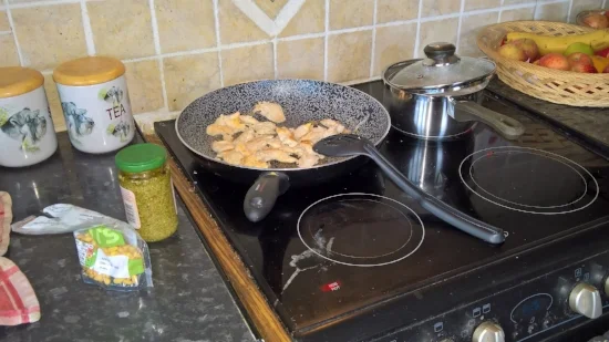 Making chicken-pesto pasta with pine nuts.