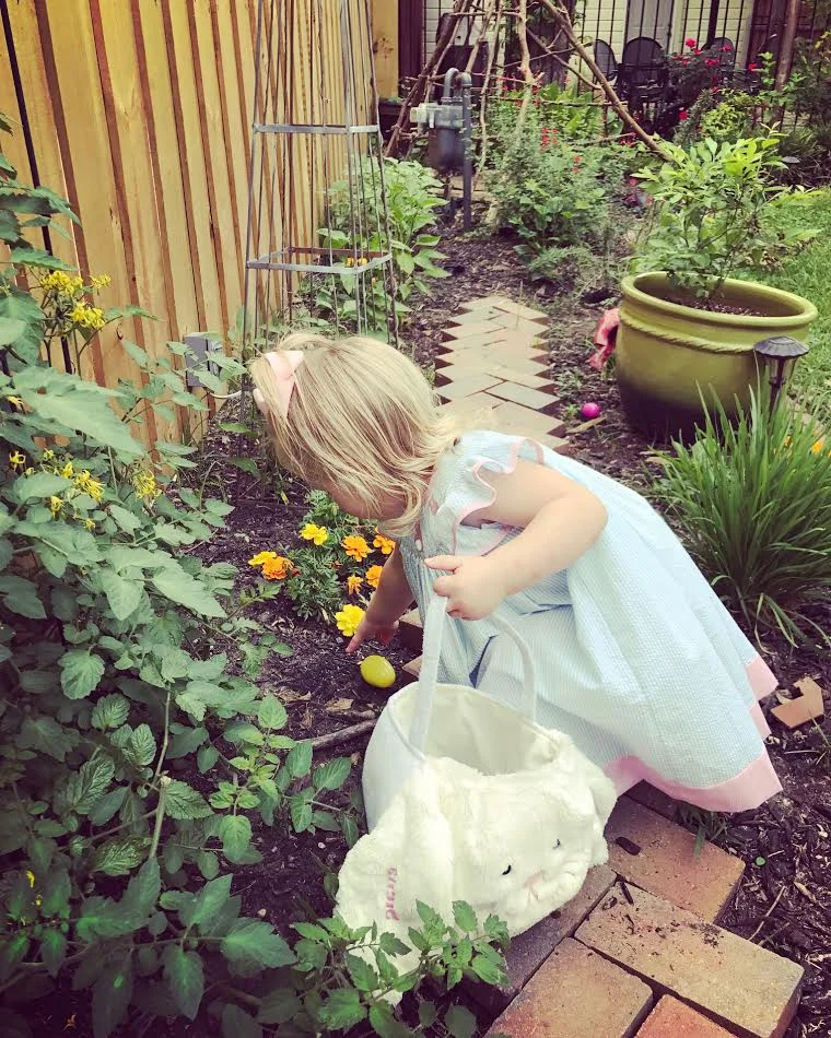 Hunting Easter eggs in the garden. Basket from Pottery Barn Kids . 