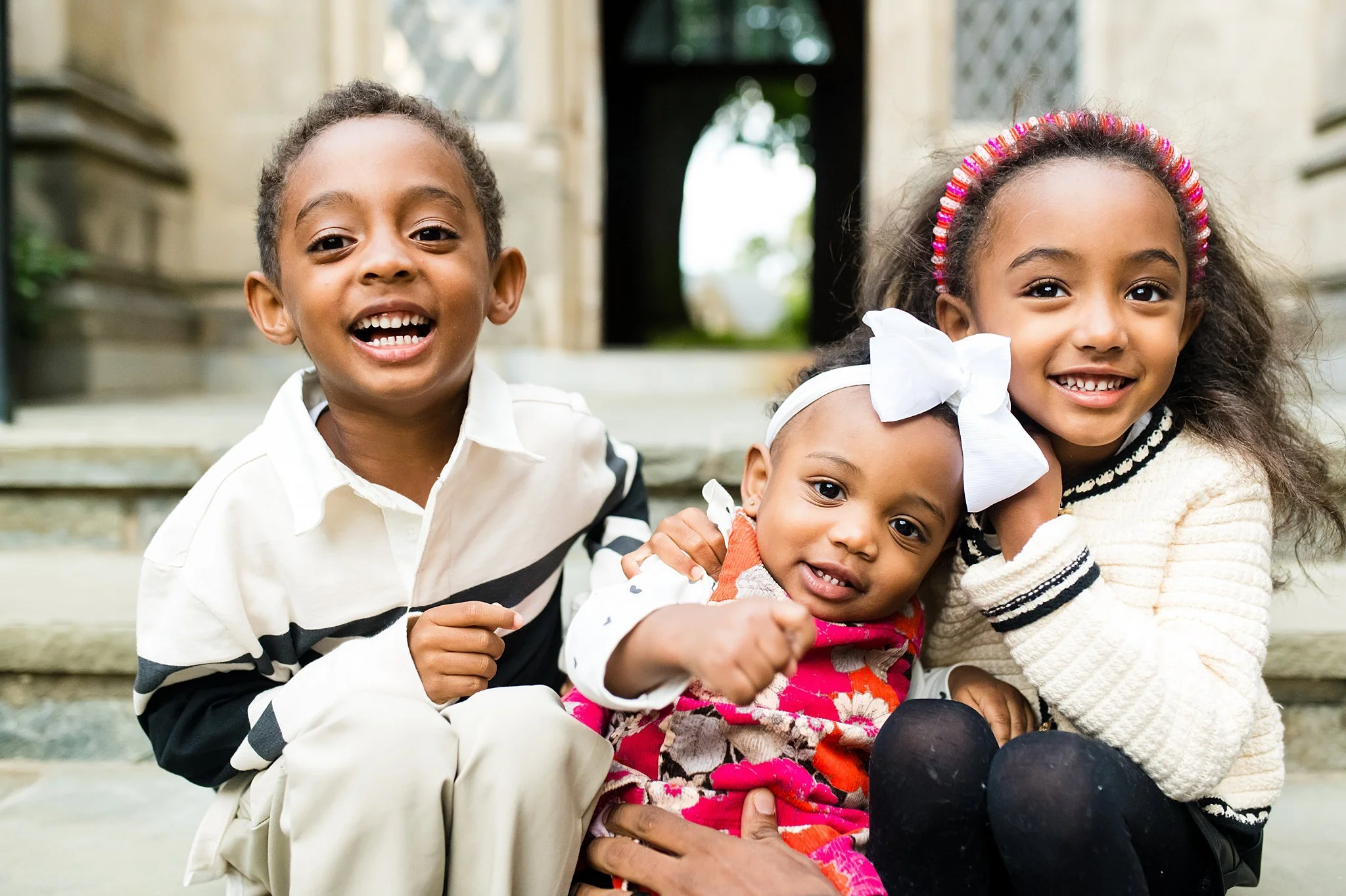 3 siblings smiling at each other at family session in Washington, DC