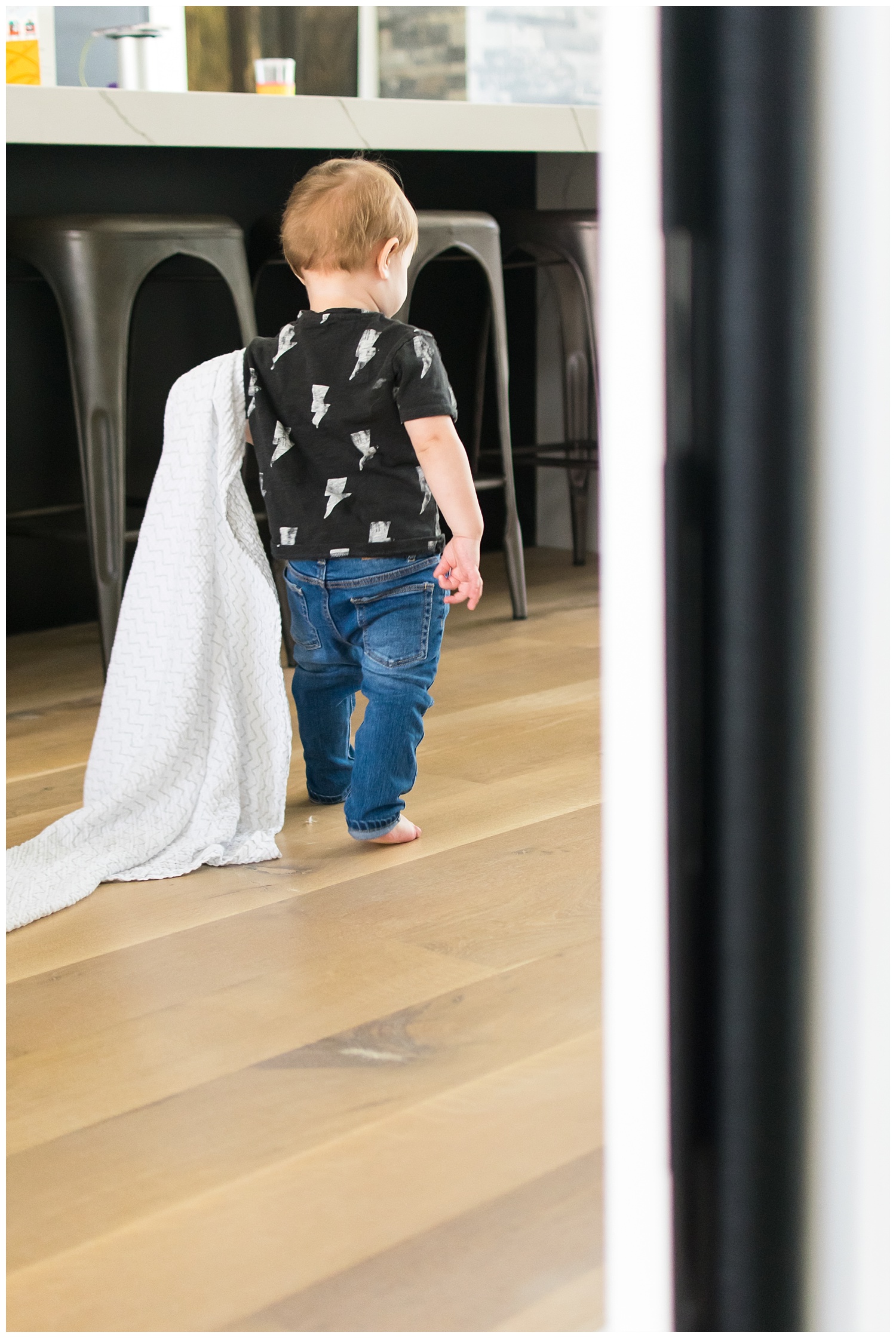 this is an image of a toddler boy walking and holding onto his blanket. the image was taken during an in home lifestyle session in atlanta georgia.