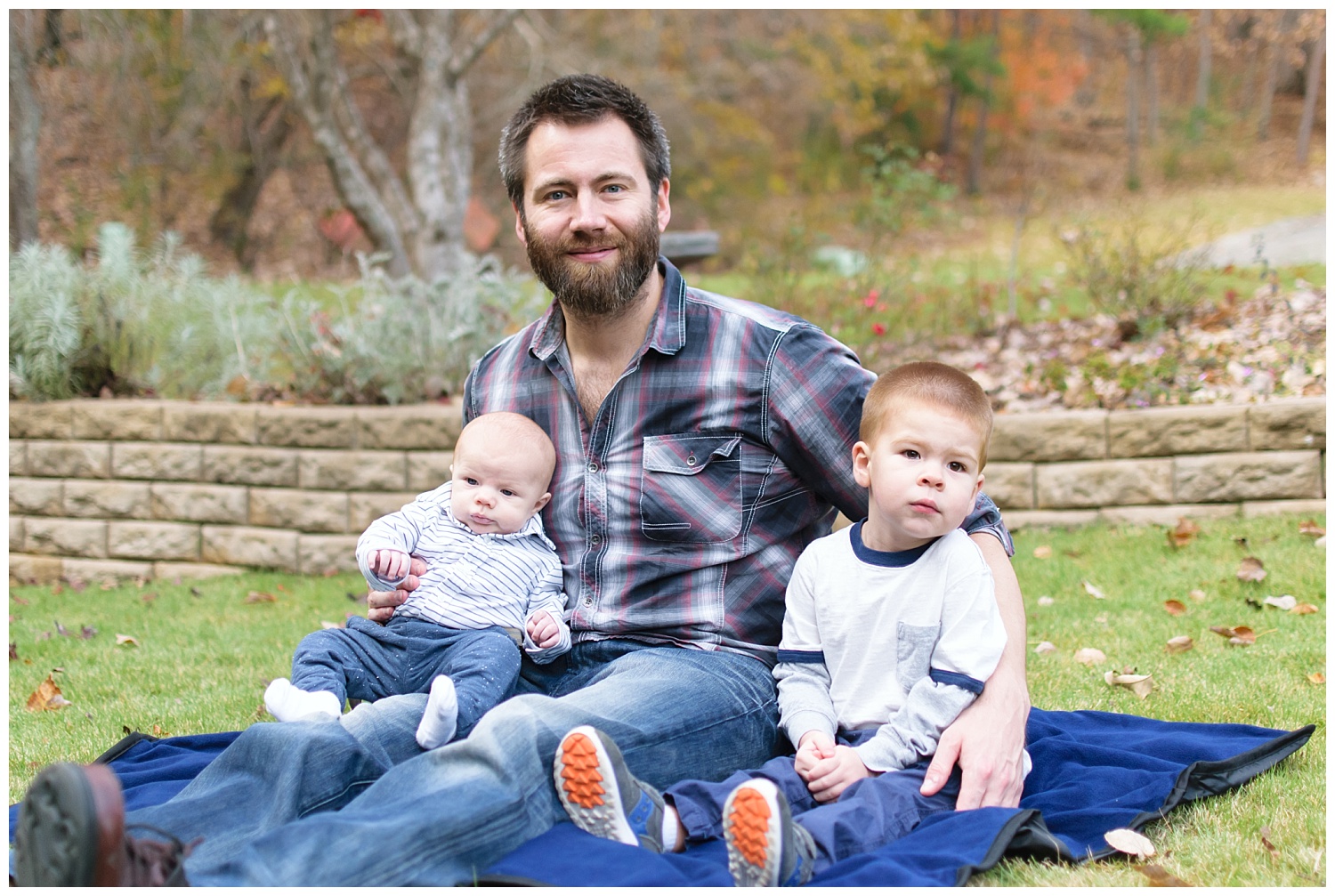 this is an image of the boys of the family during a lifestyle family session in marietta georgia. the image contains the father and the two young boys.