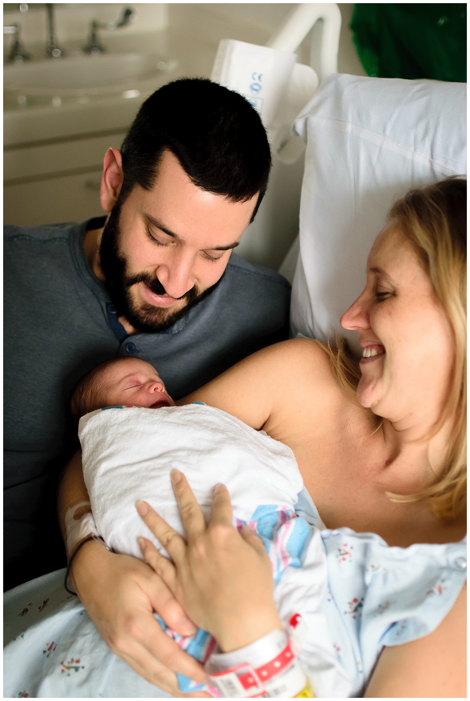 this is an image taken during a fresh 48 newborn session in atlanta georgia. mom and dad are holding and looking at their newborn baby girl.