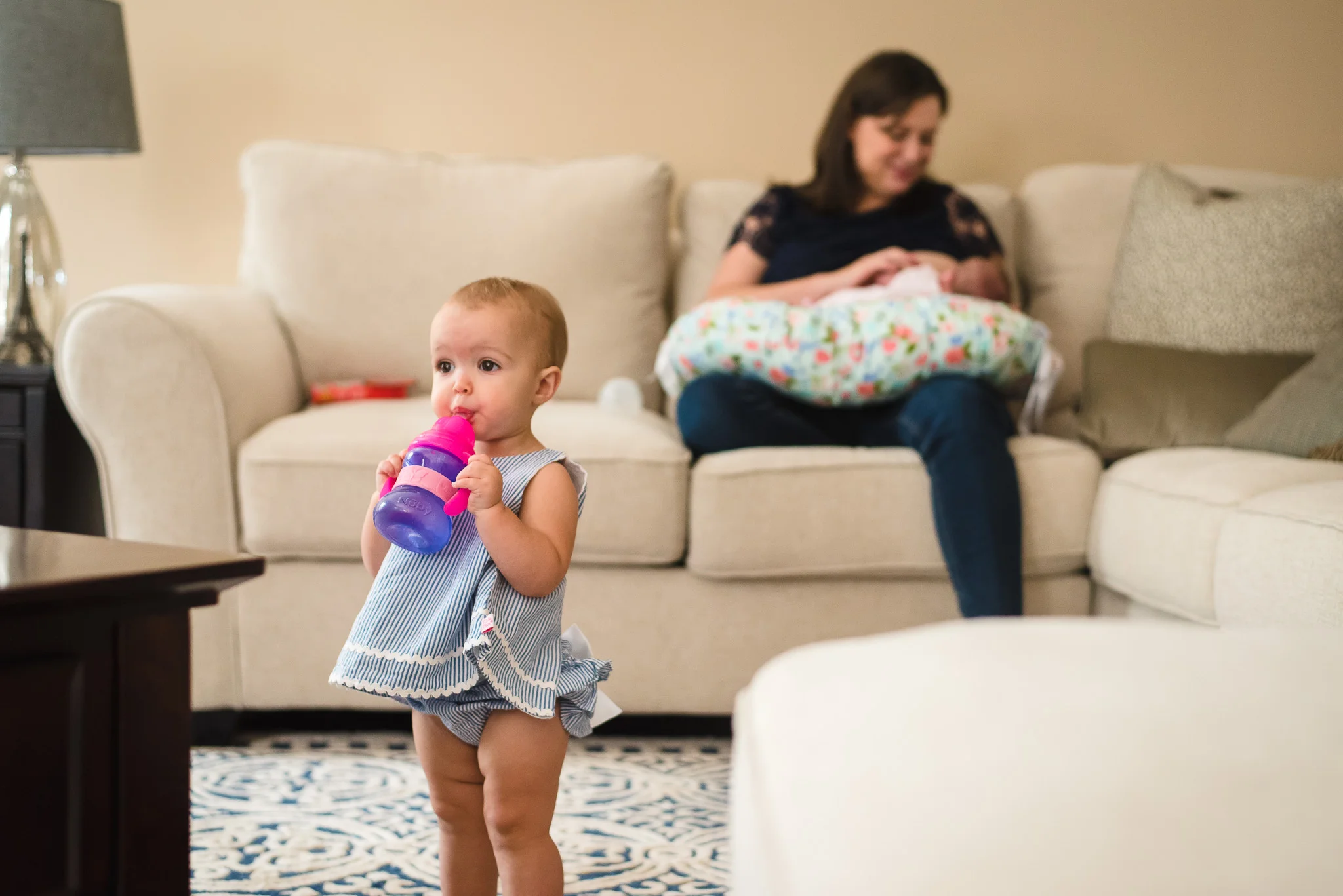 atlanta-family-photographers-toddler-drinking-water-mom-nursing-on-couch