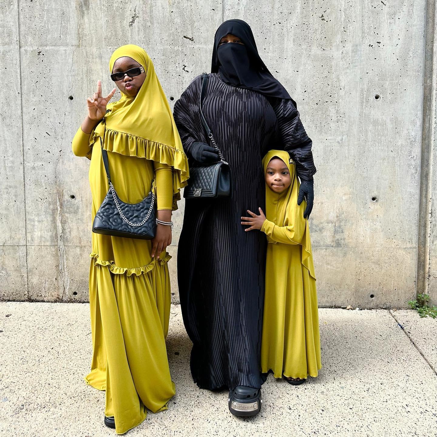 Coordinated sisters in chartreuse with mommy @itsjustnura in a sleek black abaya