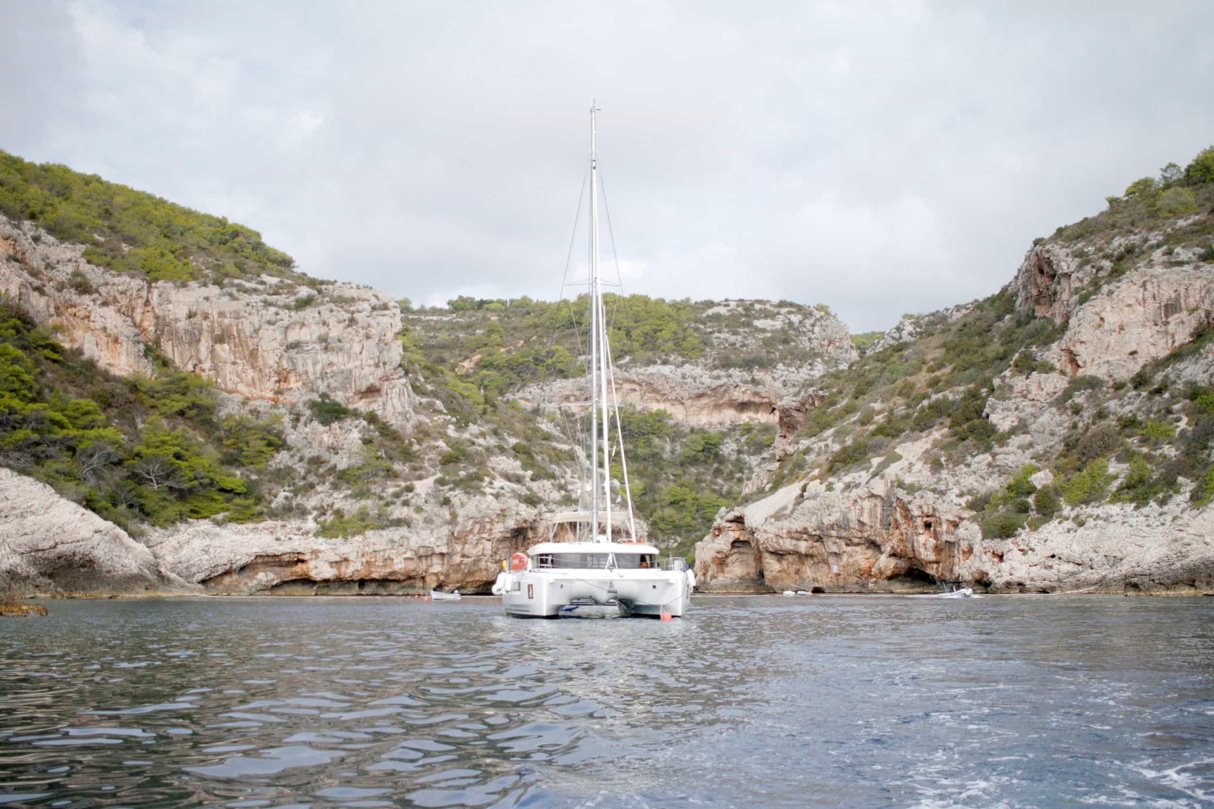 Sailboat with rocky coastline behind, near Split, Croatia