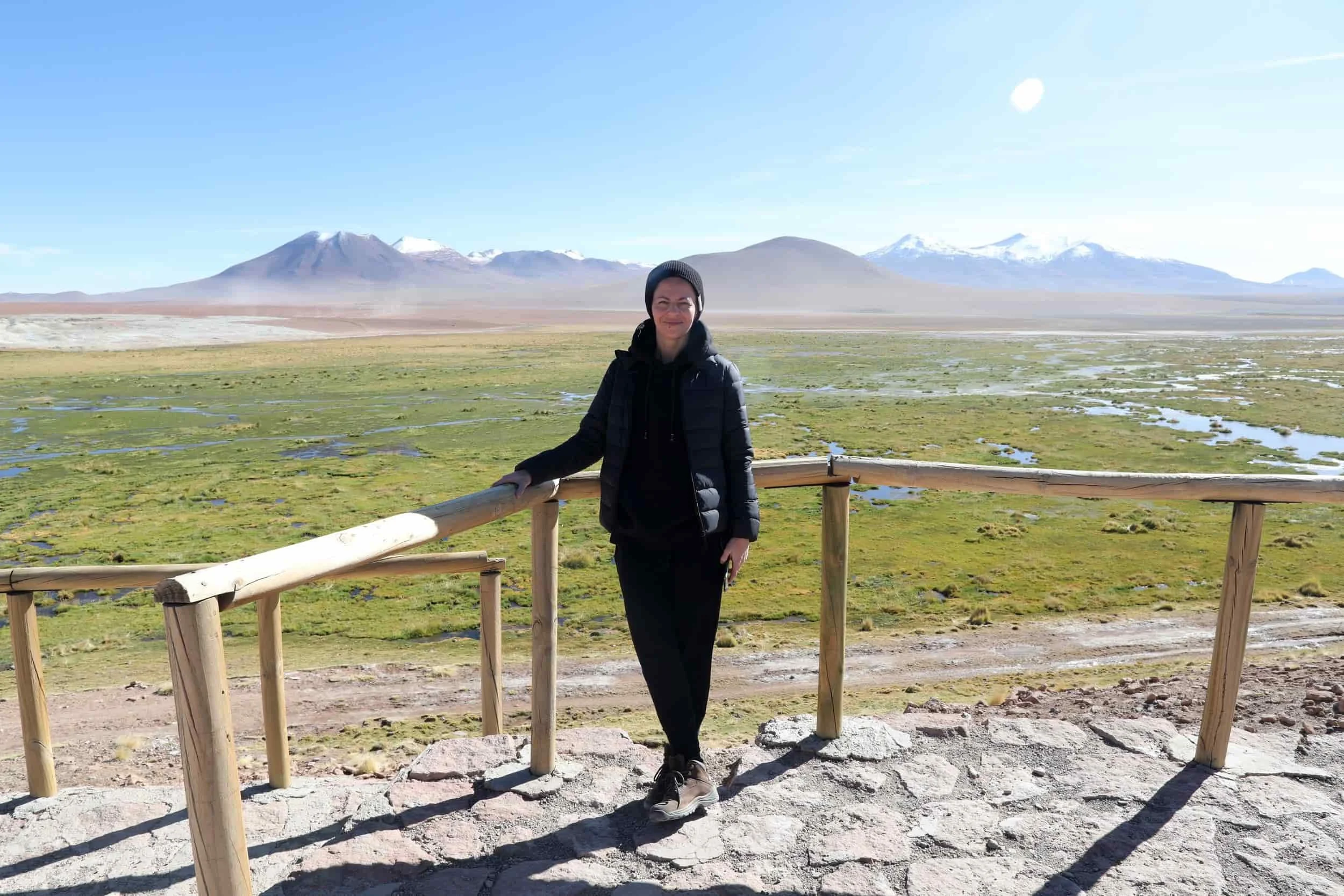 Girl standing on terrace overlooking green landscape and mountains in Peru