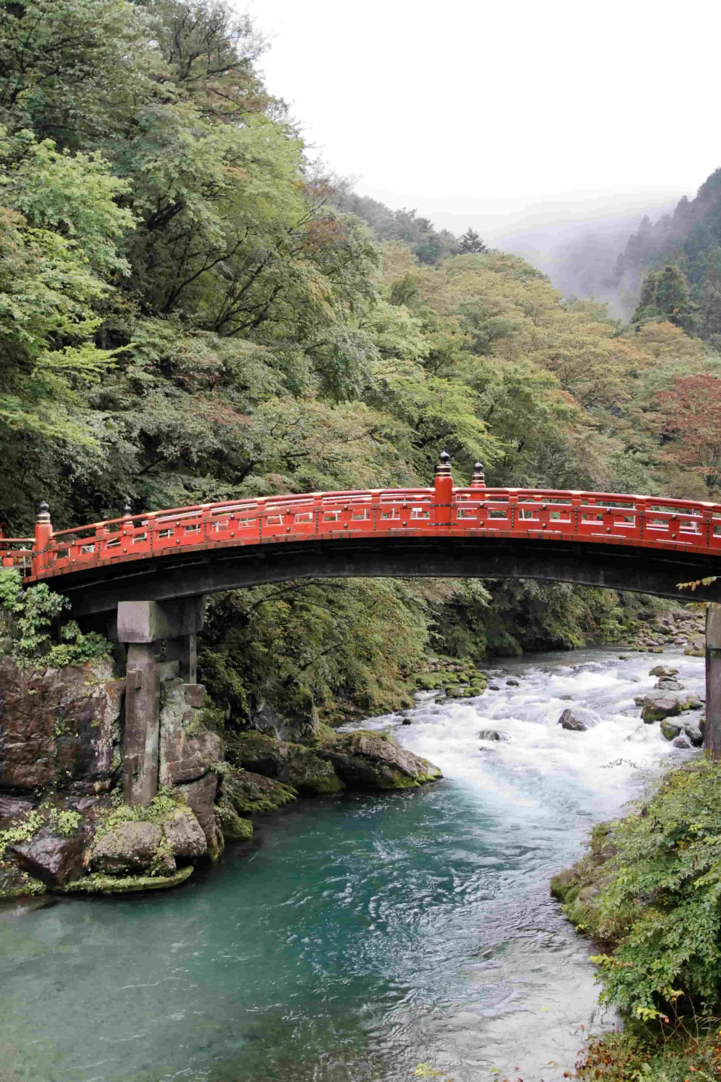 Red bridge over a river in a forest in Nikko, Japan