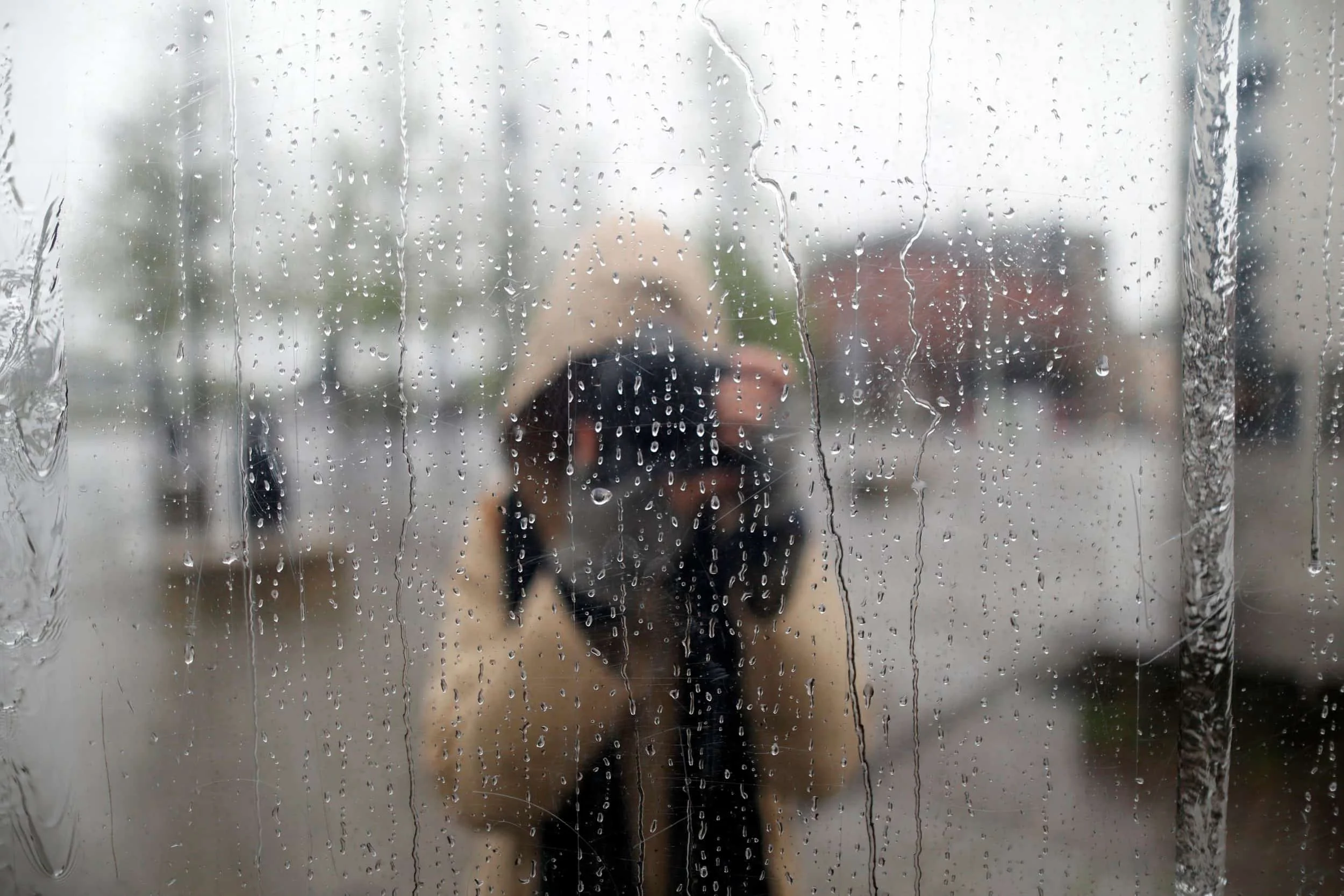 Girl photographing herself in a rainy reflection in Wales