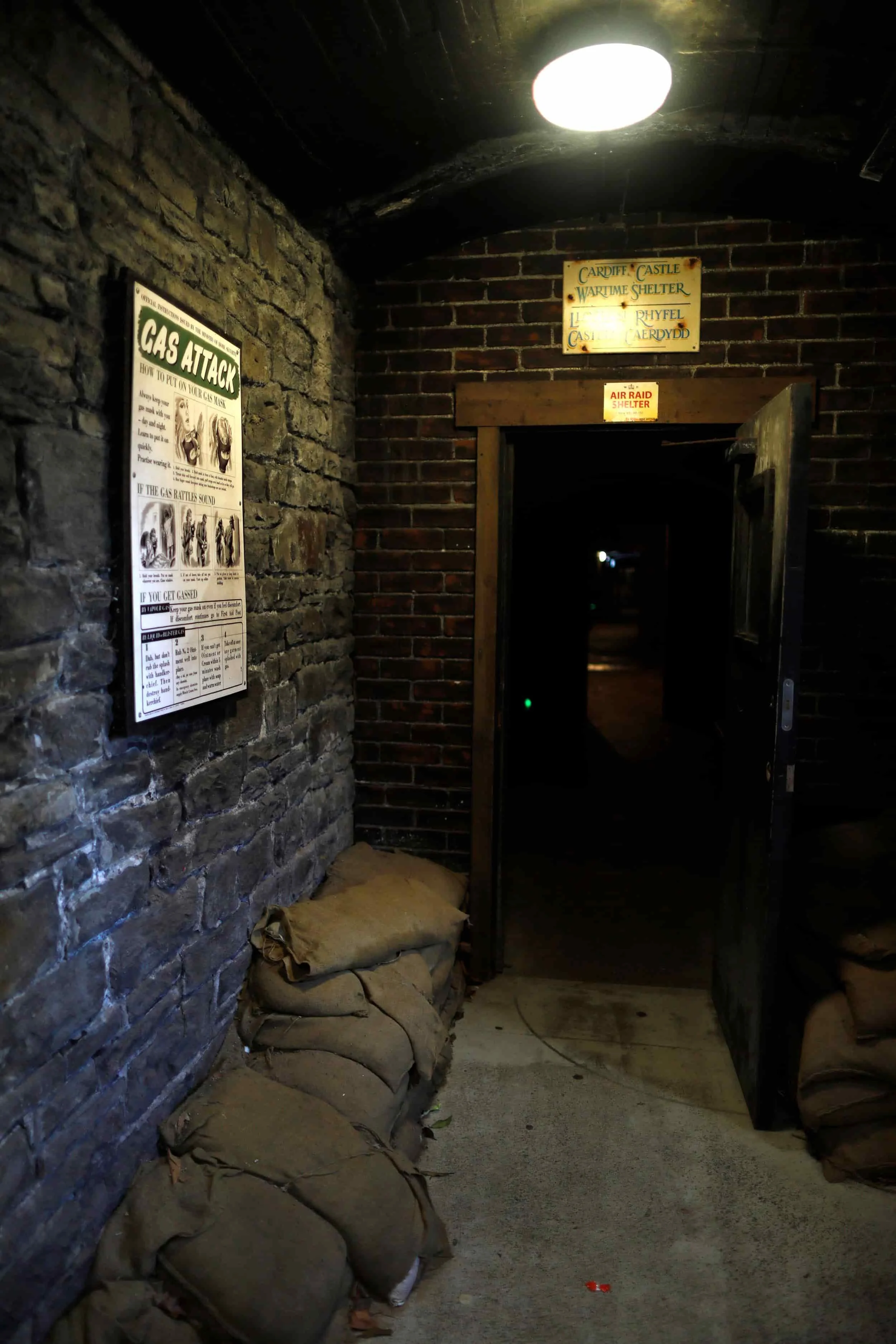 Wartime tunnels at Cardiff Castle, brick corridors with dim lights and posted signs