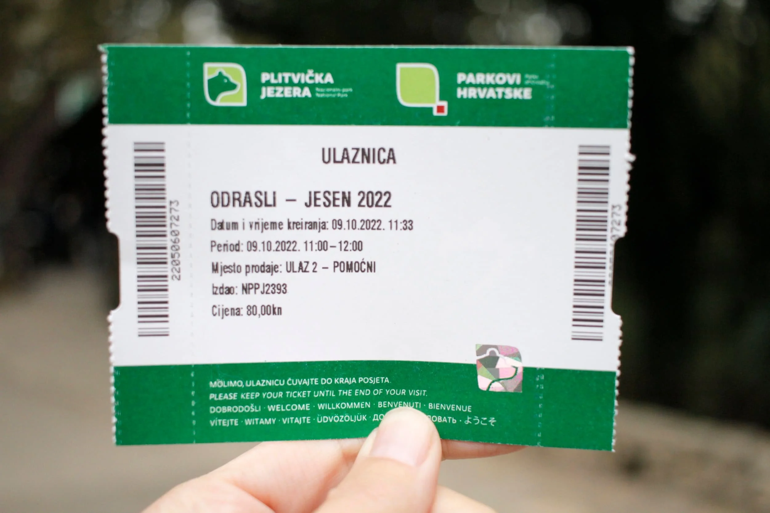 Hand holding ticket into Map of Plitviče Lakes National Park