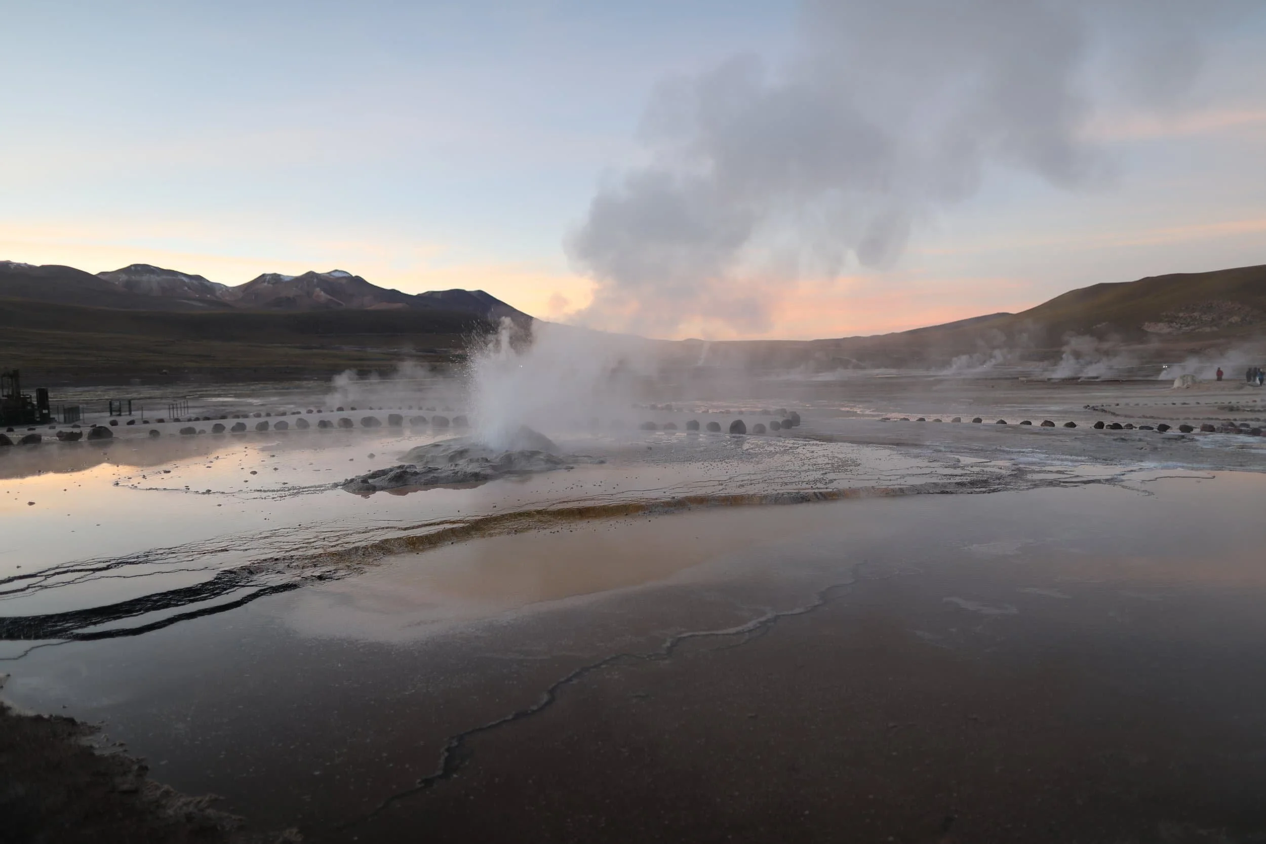 Bubbling geothermal pools and mineral-rich rock formations at El Tatio Geysers in the Atacama Desert.
