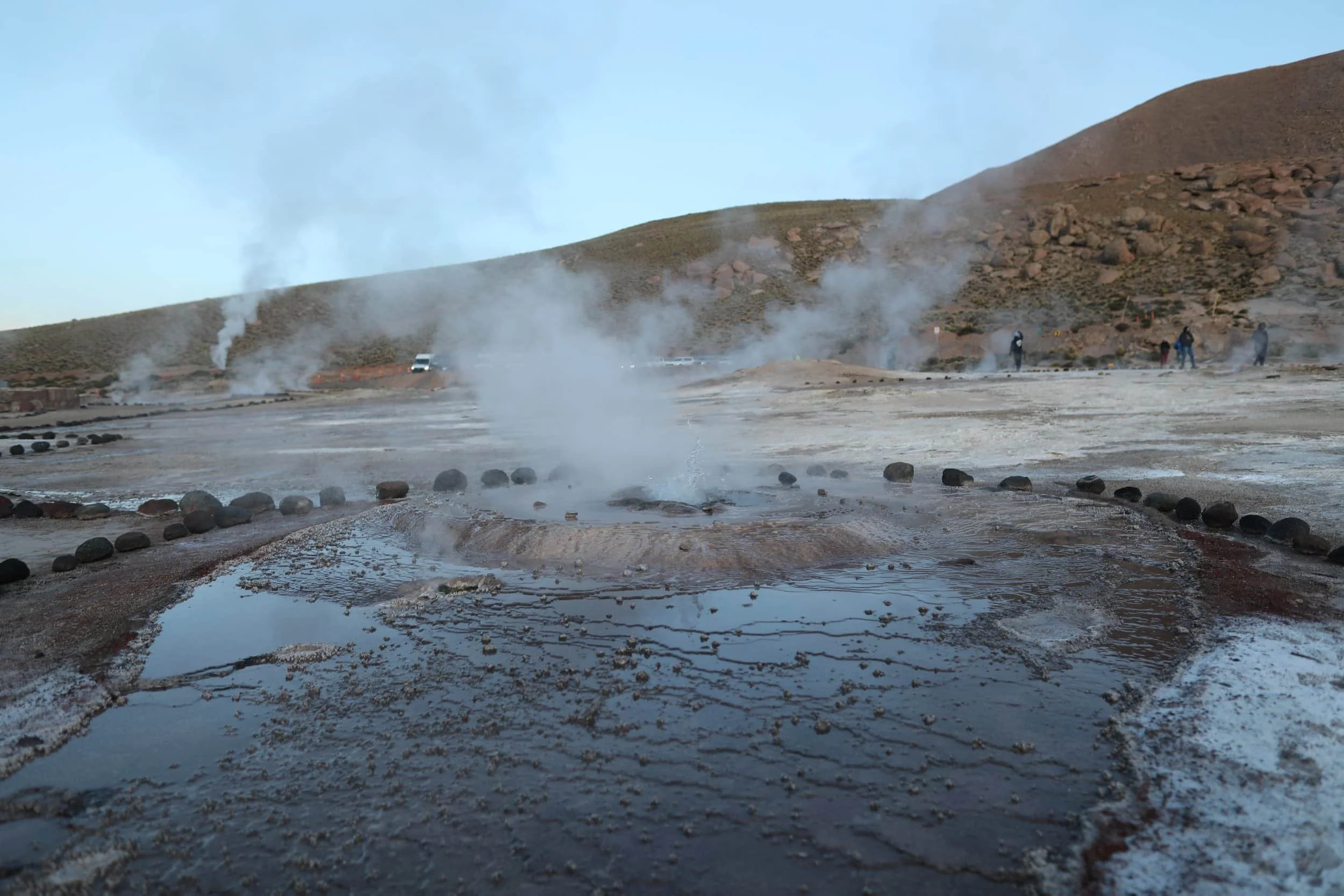 Bubbling geothermal pools and mineral-rich rock formations at El Tatio Geysers in the Atacama Desert.