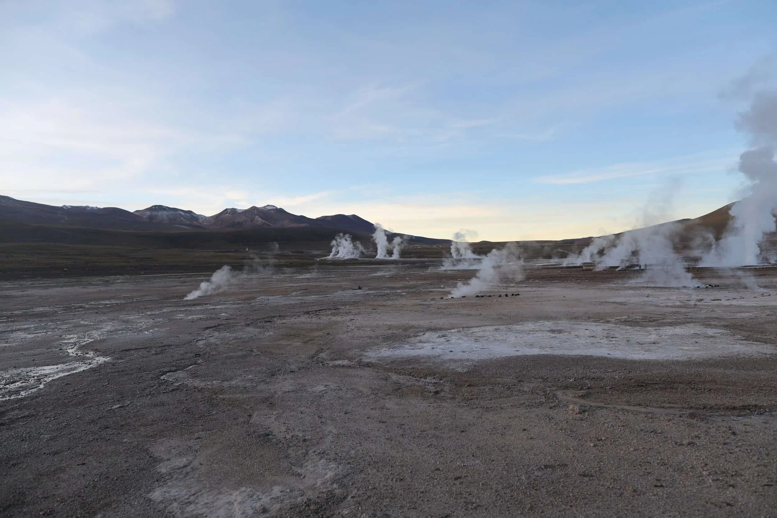 Panoramic view of El Tatio Geysers in Chile, with geothermal steam rising across the high-altitude Andes.