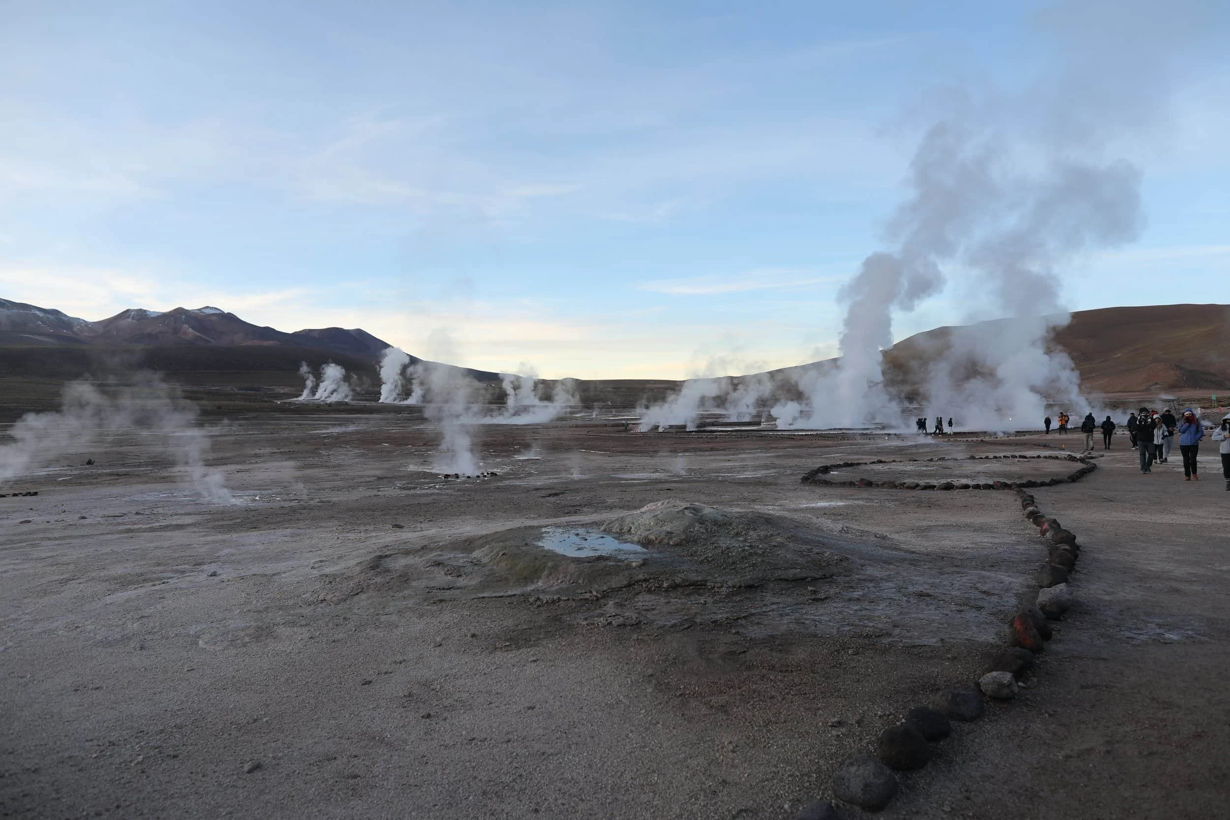 Panoramic view of El Tatio Geysers in Chile, with geothermal steam rising across the high-altitude Andes.