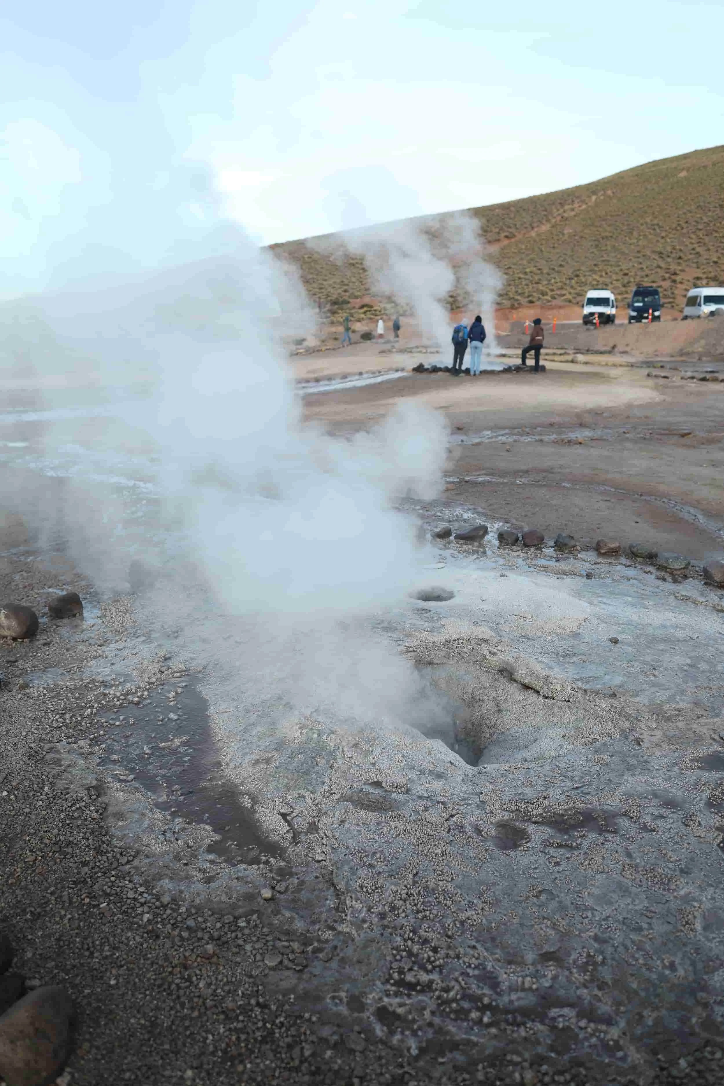 Bubbling geothermal pools and mineral-rich rock formations at El Tatio Geysers in the Atacama Desert.