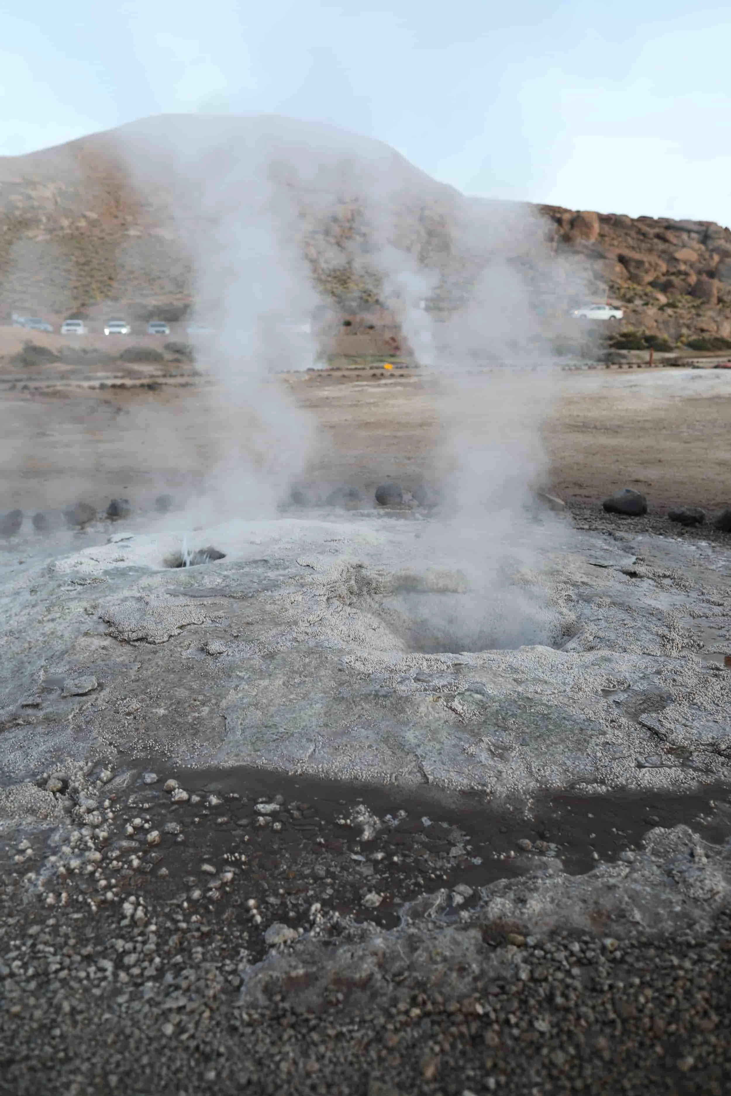 Bubbling geothermal pools and mineral-rich rock formations at El Tatio Geysers in the Atacama Desert.