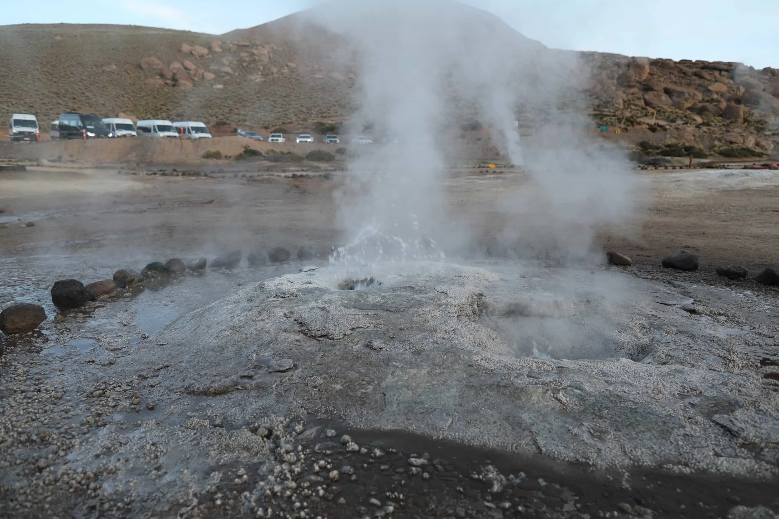 Bubbling geothermal pools and mineral-rich rock formations at El Tatio Geysers in the Atacama Desert.
